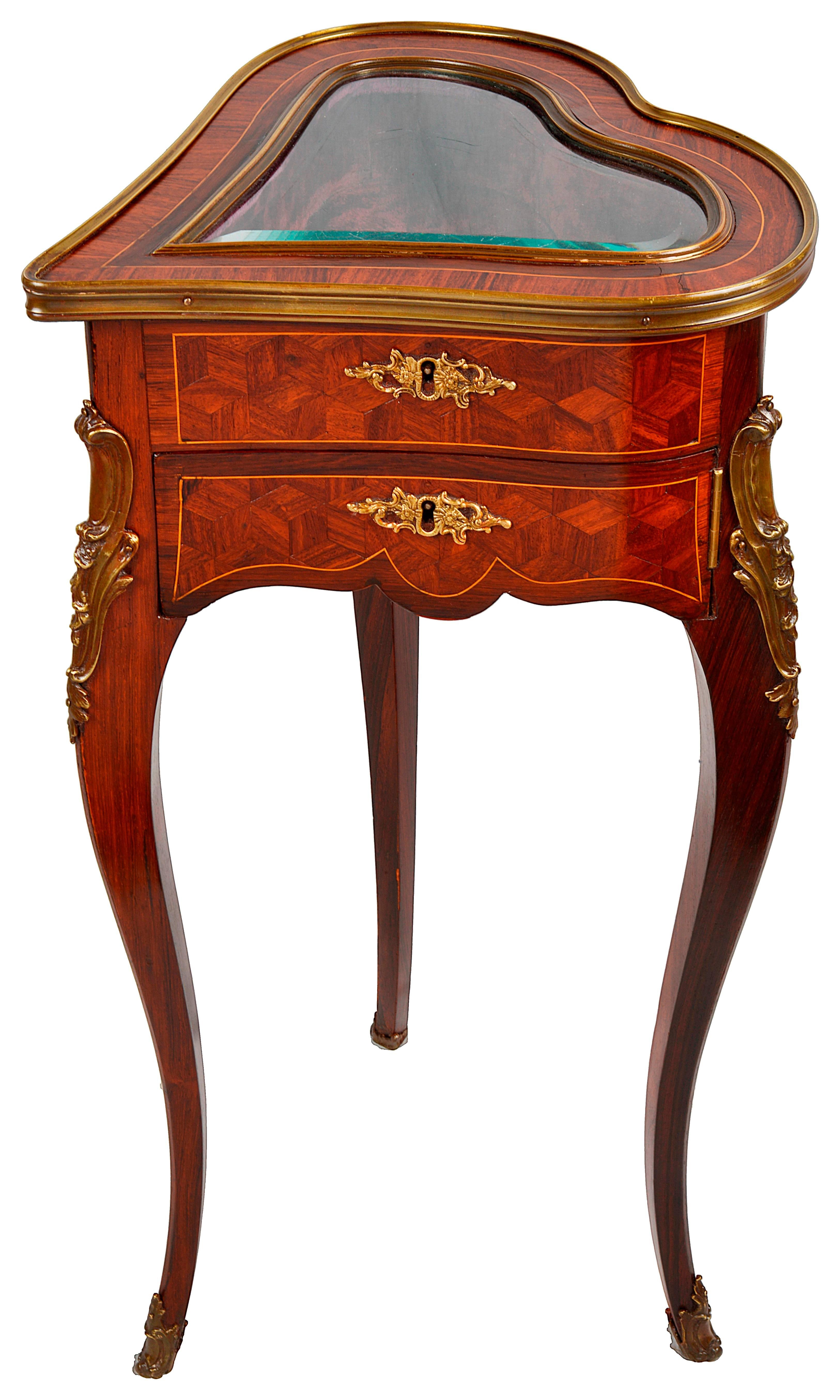 A good quality late 19th century parquetry inlaid heart shaped bijouterie cabinet. Having ormolu mounts, red velvet lining, raised on cabriole legs.