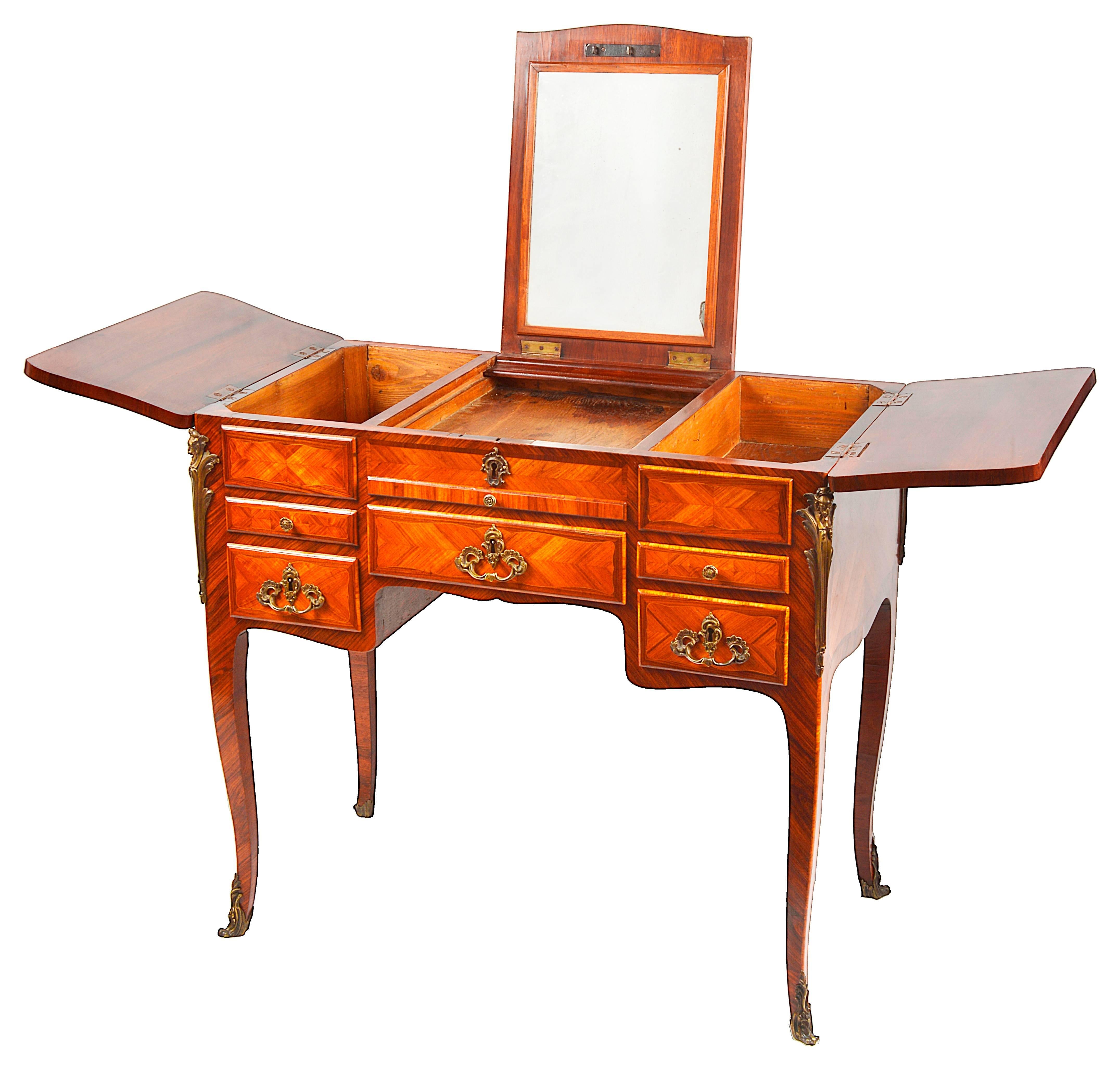 A good quality mid-19th century French King wood parquetry inlaid ladies dressing table. The top hinging open to reveal a mirror in the centre section, the two sides open to reveal compartments, drawers and a writing slide beneath. Ormolu mounts and