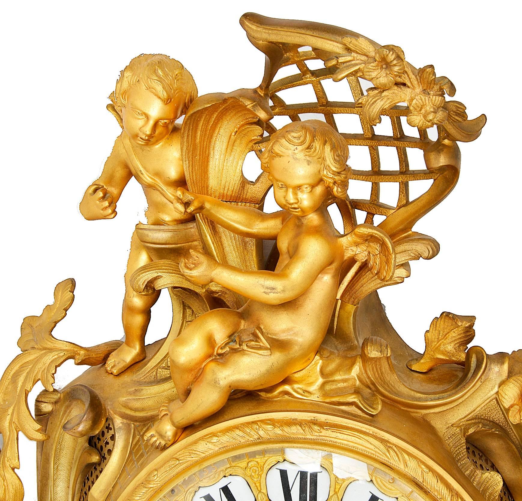 Pendule murale en bronze doré français de bonne qualité, datant du 19e siècle, présentant des influences rococo dans la décoration feuillagée et les chérubins au-dessus du mouvement à sonnerie de huit jours, vers 1880.