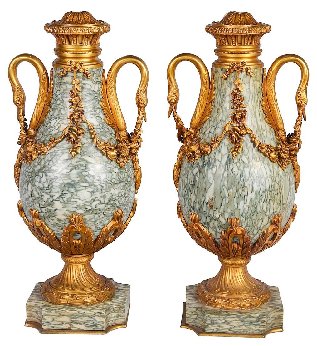 A good quality pair of gilded ormolu-mounted marble urns, each with swan neck handles and swags of flowers. Converted to lamps.