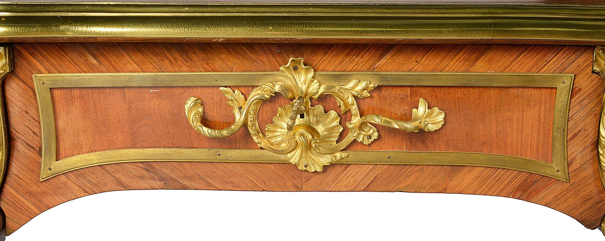 A very good quality 19th century Louis XV style bureau plat, having an inset leather top, gilded ormolu mounts, three frieze drawers to one side, dummy drawers to the reverse, raise on cabriole legs each with wonderful gilded ormolu mounts.