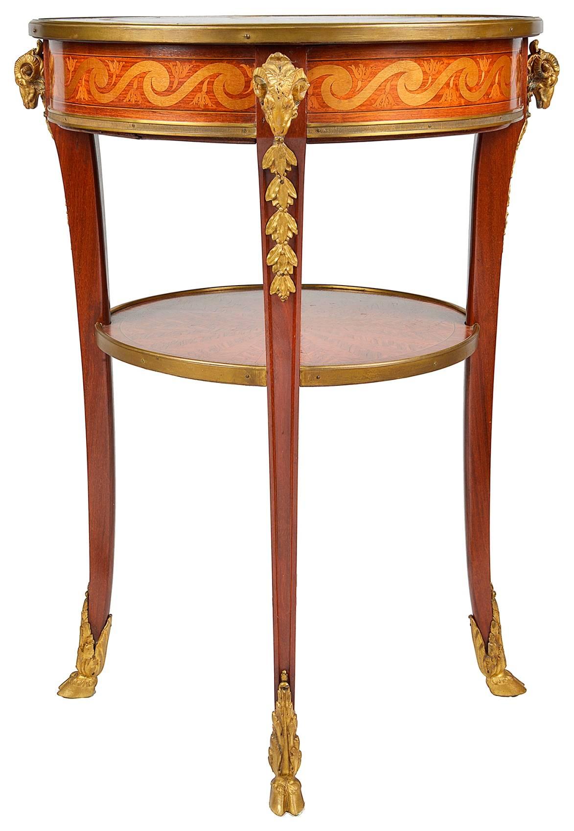 A good quality marquetry and parquetry inlaid side table, in the style of Louis XV. Having radiating veneers from center tabletop with marquetry crossbanding. Gilded ormolu ram's head mounts to the four out swept legs and an under tier.