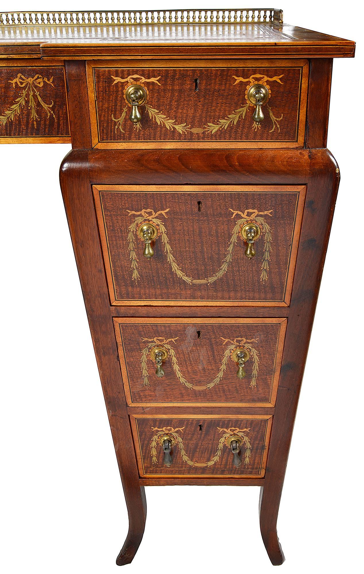 A very good quality late 19th century mahogany inlaid writing desk, stamped Edwards and Roberts. Having a brass gallery to the top, with an inset leather tooled top. Three frieze drawers each with inlaid garlands of flowers, three graduating drawers