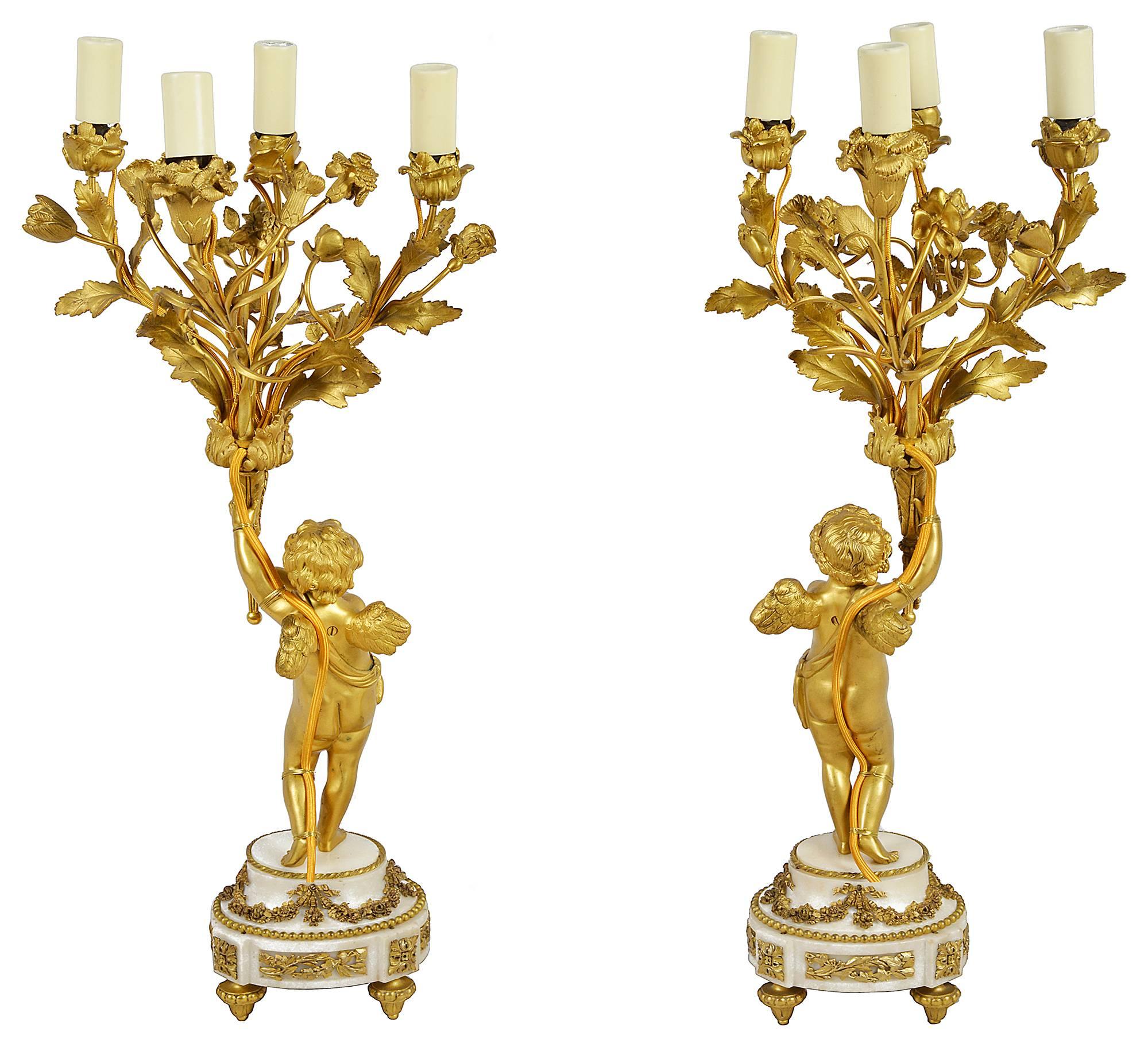 A good quality pair of 19th century gilded ormolu, Louis XVI style candelabra, each with cherubs mounted on white marble bases and holding four branch flower like candelabra.