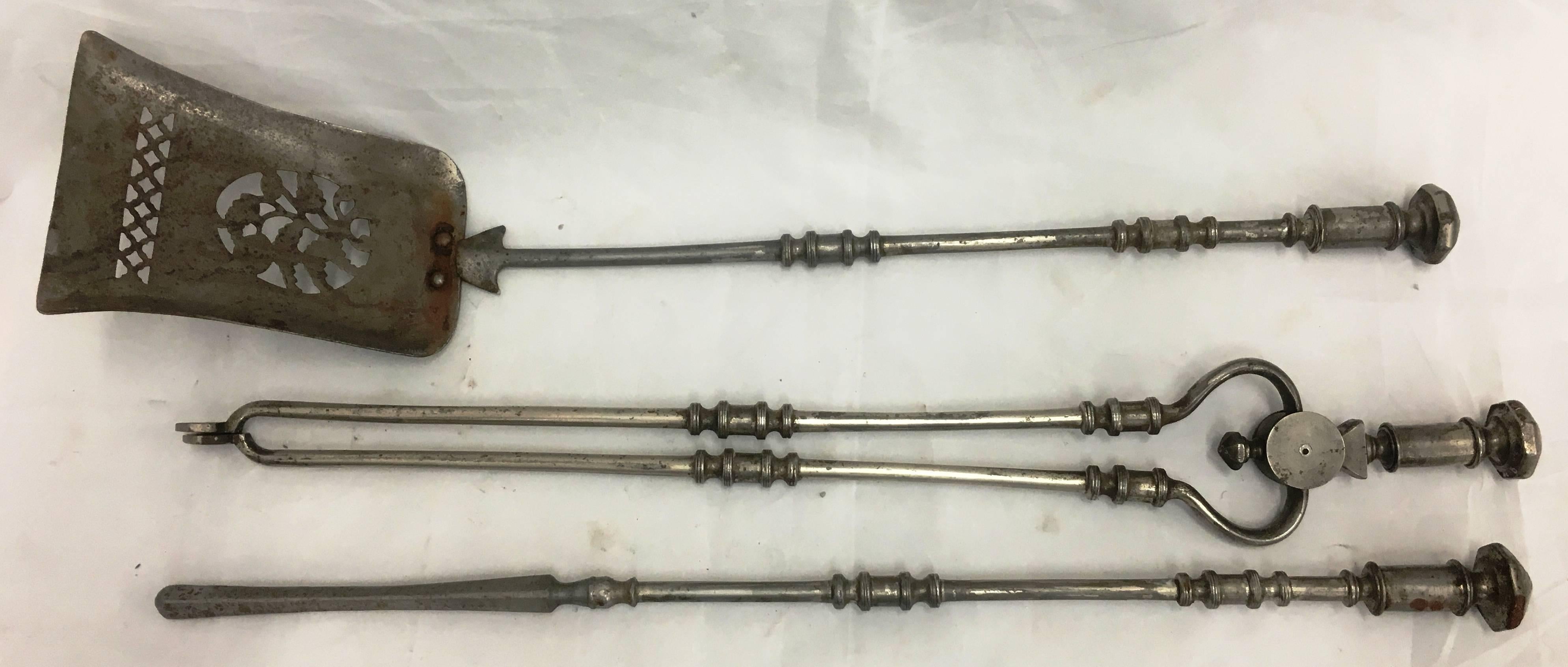 A good quality pair of Georgian steel fire irons, comprising of a pair of fire dogs, shovel, poker and tongs. Each have ring turned detail and a faceted finials.