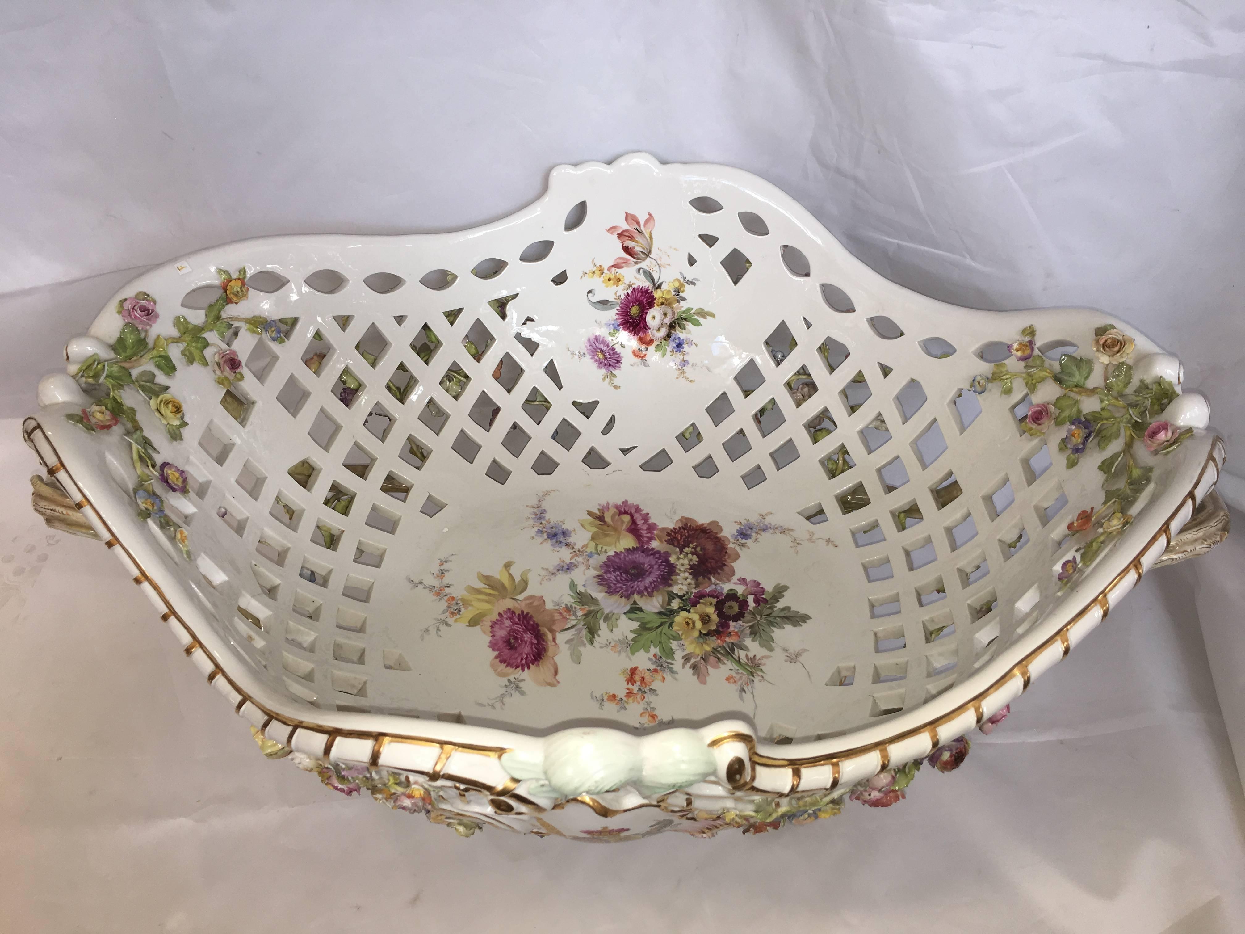 A monumental Meissen reticulated flower-encrusted basket
Late 19th-early 20th century, blue crossed swords mark, IMPRESSED C.6., IMPRESSED 79, PAINTED 14.
Of rocaille-moulded lozenge form, the interior painted with a loose bouquet and two flower