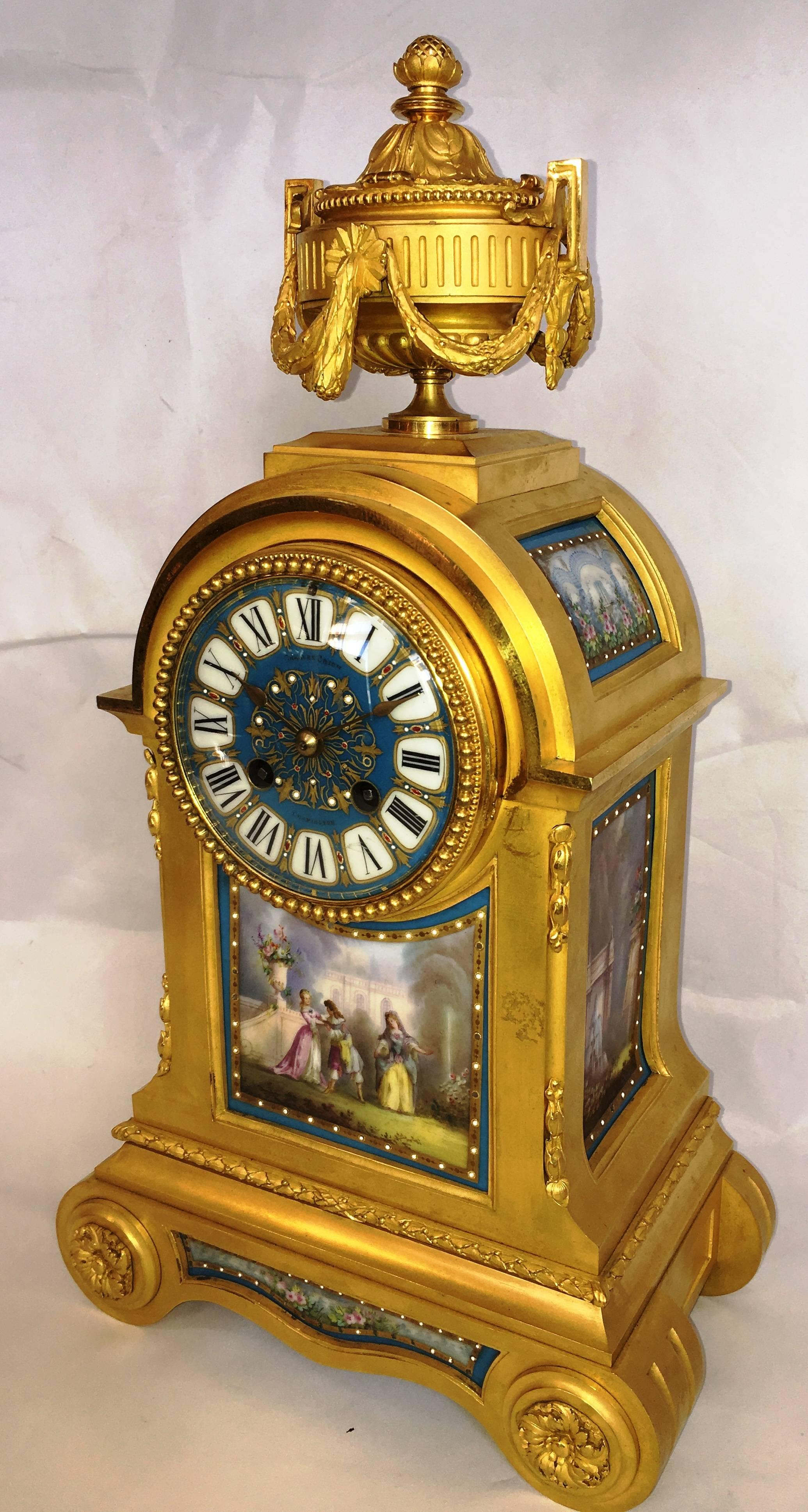 A very good quality 19th century French gilded ormolu mantel clock, having Sevres style porcelain panels, depicting a romantic scene, a gilded ormolu urn with swags above the clock face, the movement being of an eight day duration and chiming every