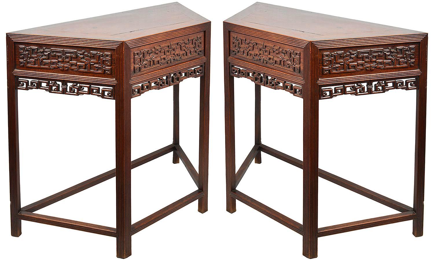 A good quality pair of late 19th century Chinese hardwood console tables, each with carved blind fretwork and pierced, reeded decoration to the legs and a single drawer. Having a stretcher to each of the bases.