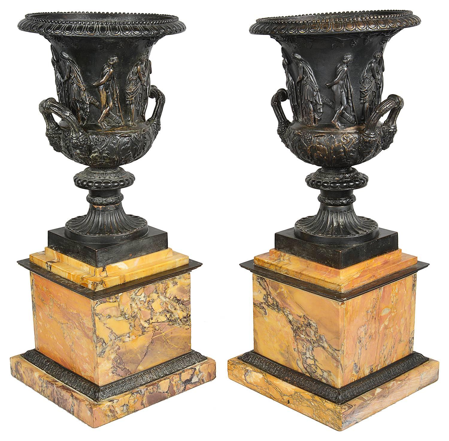 An impressive large pair of classical bronze urns, after the Medici and Borghese models. Each mounted on Sienna marble plinths.