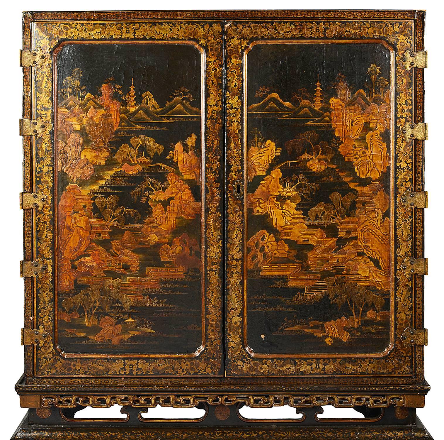 A wonderful quality 18th century Chinese export lacquer cabinet on stand. Having classical black lacquer and gilded Chinoiserie decoration. The pair of doors opening to reveal this spectacular fitted interior, with drawers, cupboards and