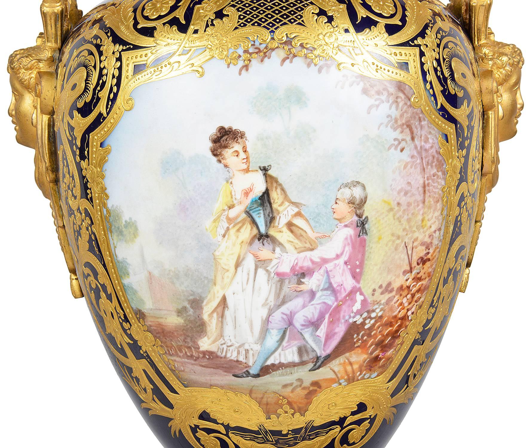 Sehr gute Qualität einer französischen Sèvres-Deckelvase aus dem späten 19. Mit vergoldetem Ormolu auf kobaltblauem Hintergrund mit vergoldetem Rollendekor. Die bemalte Tafel auf der Vorderseite stellt eine klassische romantische Szene dar.