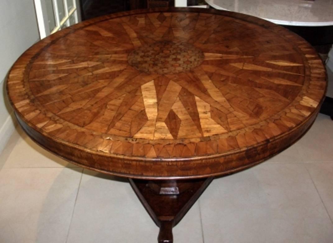A very impressive 18th century Italian parquetry inlaid centre table. Having radiating fruitwood inlaid decoration to the top and frieze. Mounted on a central pedestal, tri-form base, again having parquetry inlay and raised on carved claw feet.