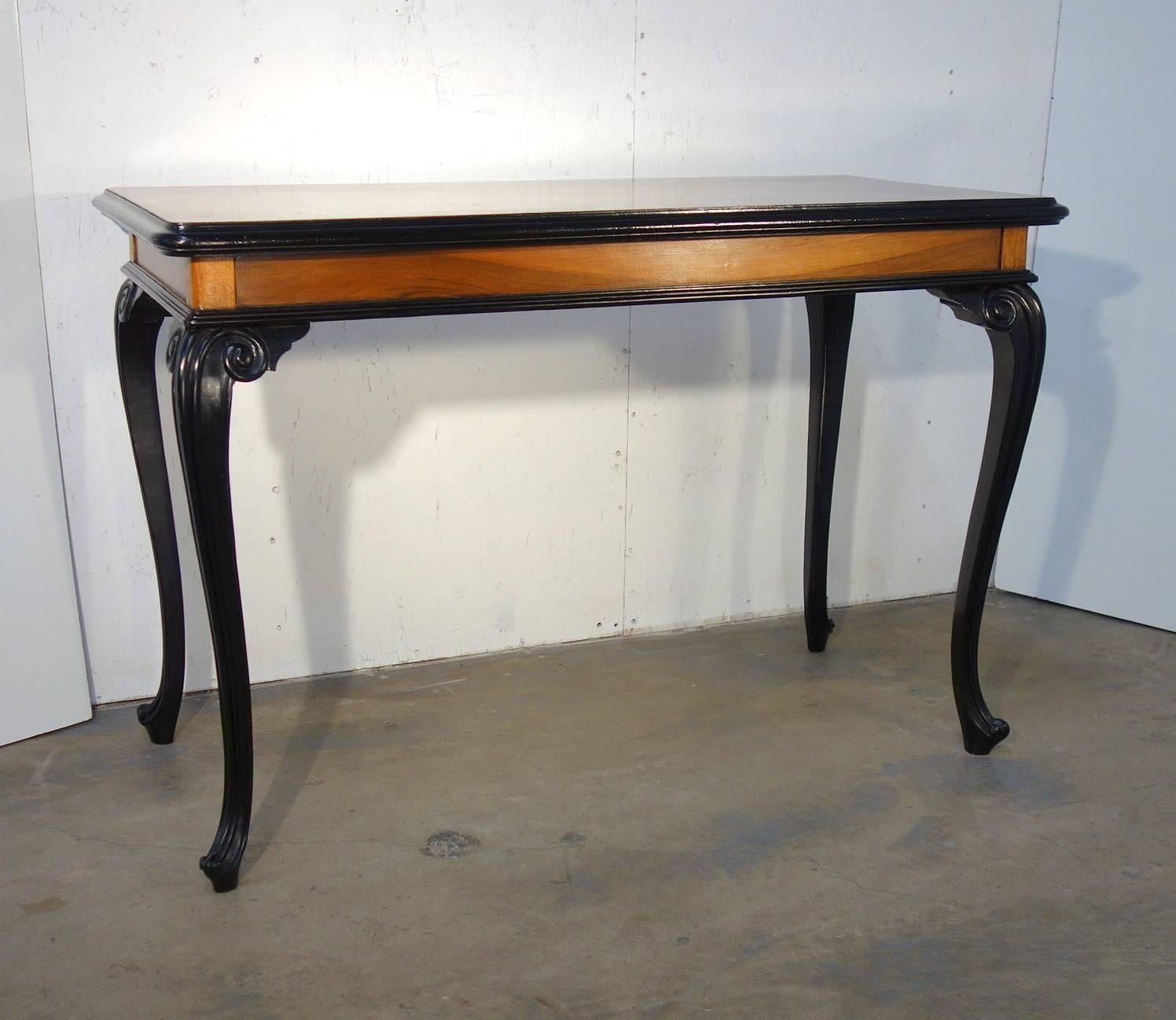 Mitteltisch im lombardischen Stil aus Nussbaum mit vier geschwungenen Beinen und Ebenholzprofilen. Wunderbare moderne Linie, sauber und elegant. 
Stilvoll für einen kleinen Eingangstisch oder Schreibtisch.
Maße: 47