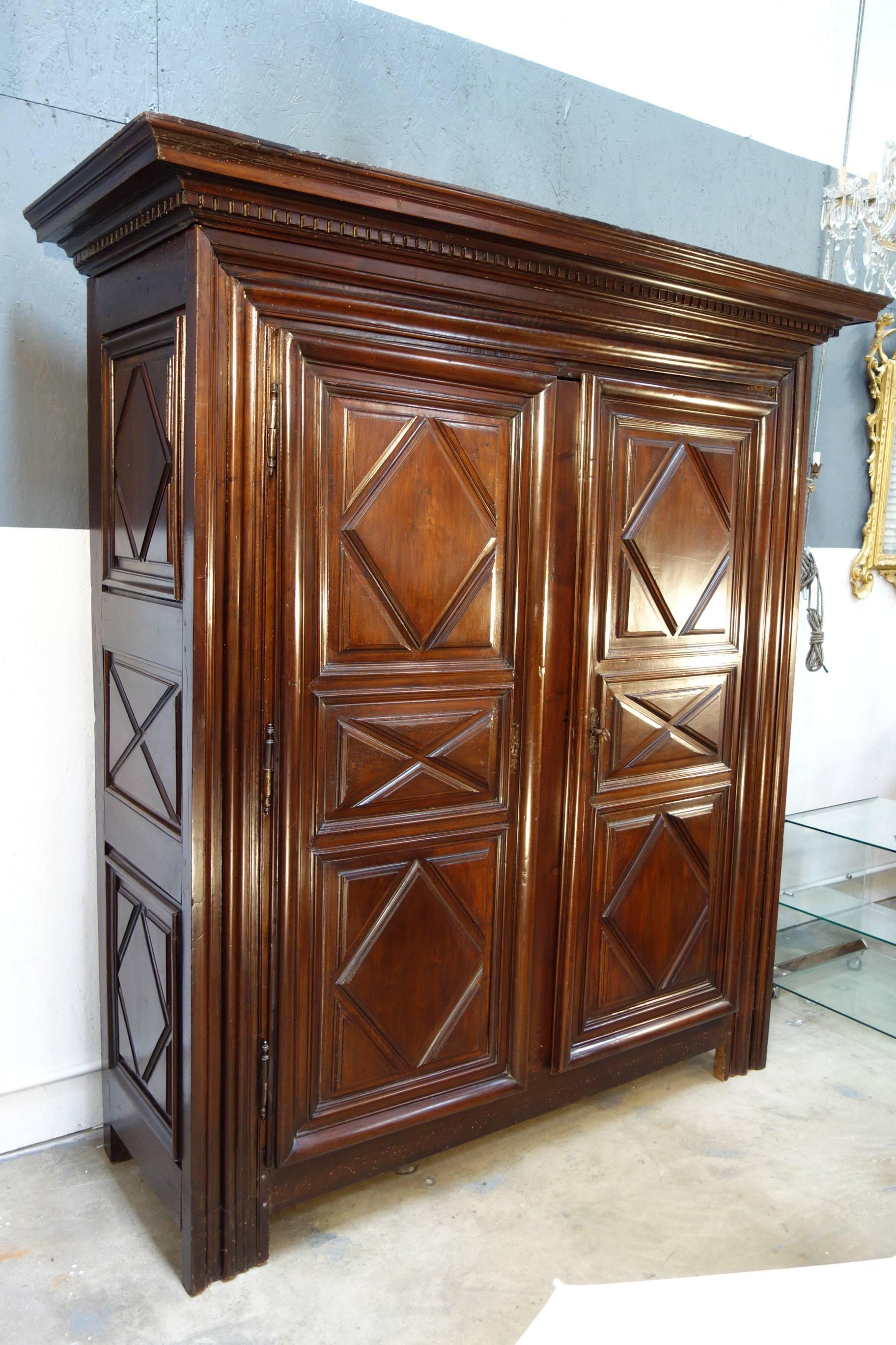 Late 17th century Louis XIII walnut armoire, all solid walnut paneled sides and doors. Originally was a two-door armoire with a center jamb then in a later time was modified in order to be able to open completely. Original key and lock. The frame it