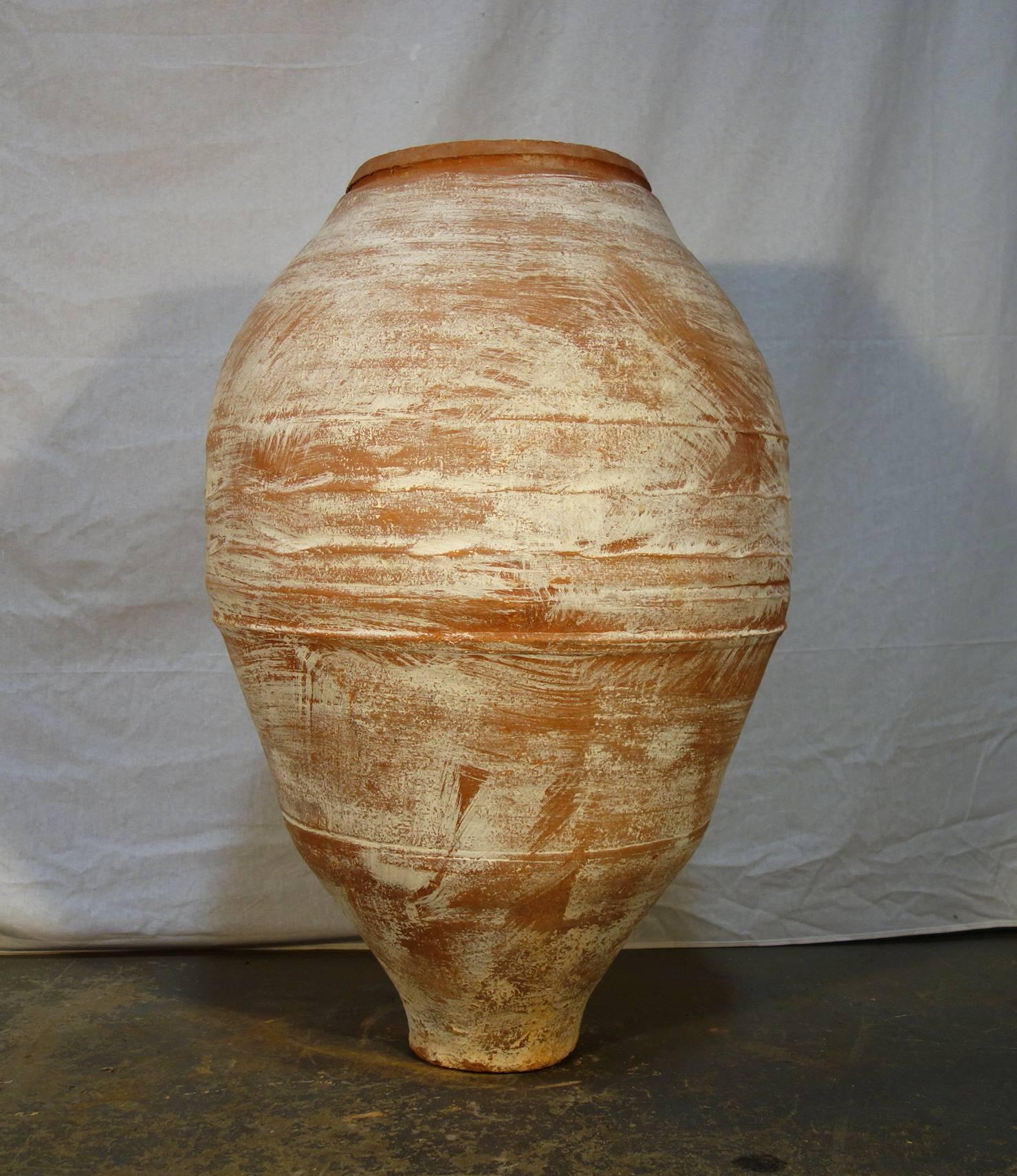 Simple line 19th century Greek water Amphora wonderful white lime patina, it was once used as storage and shipping jars for water. Tapered shape toward the bottom, with geometric and midwidth scoring.
Moderate white patina.
Dimensions are:  21
