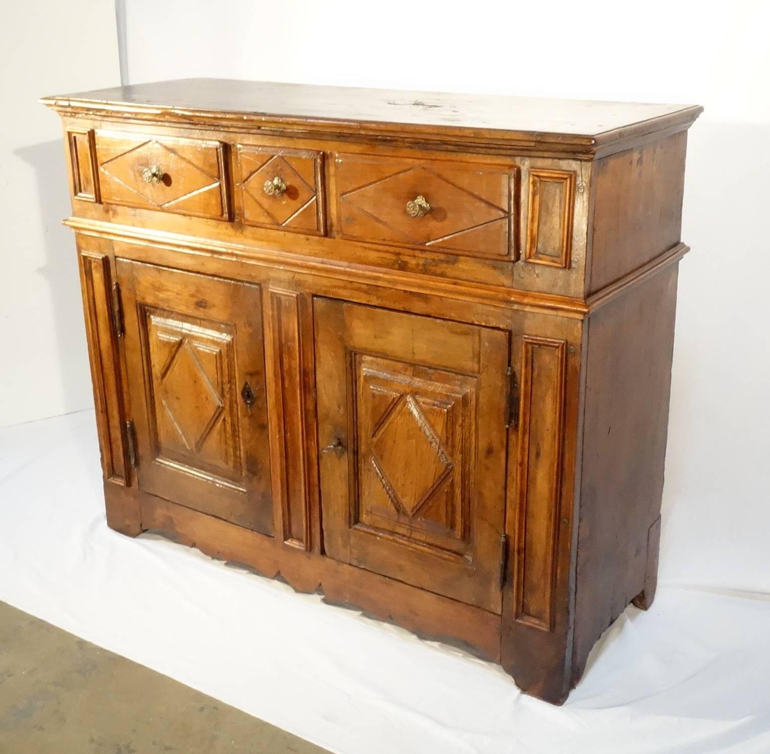 Elegant and clean Tuscan credenza, 17th century style, solid walnut with three-drawer on the top and two-door. Diamond shape door, Classic elegant molding and geometric lines make it a really charming piece, circa 1880.

Measures: 49.75" W x