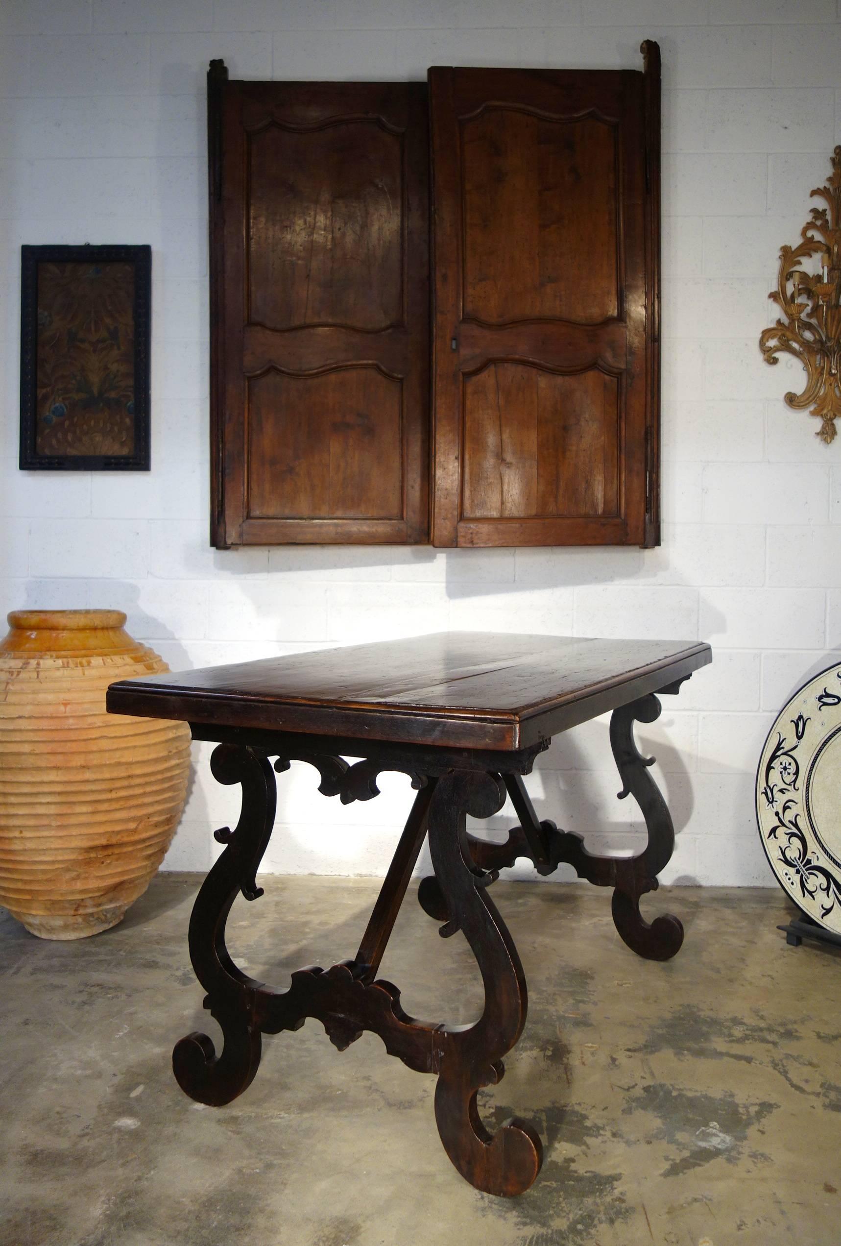 Very old Tuscan solid walnut table top, two planks from the 17th century, with a refectory style base of lyre legs and crossbar supports, 19th century.
Simple dramatic clean lines. 

Measures: 60.5" L x 31.25" D x 33.75" H.
