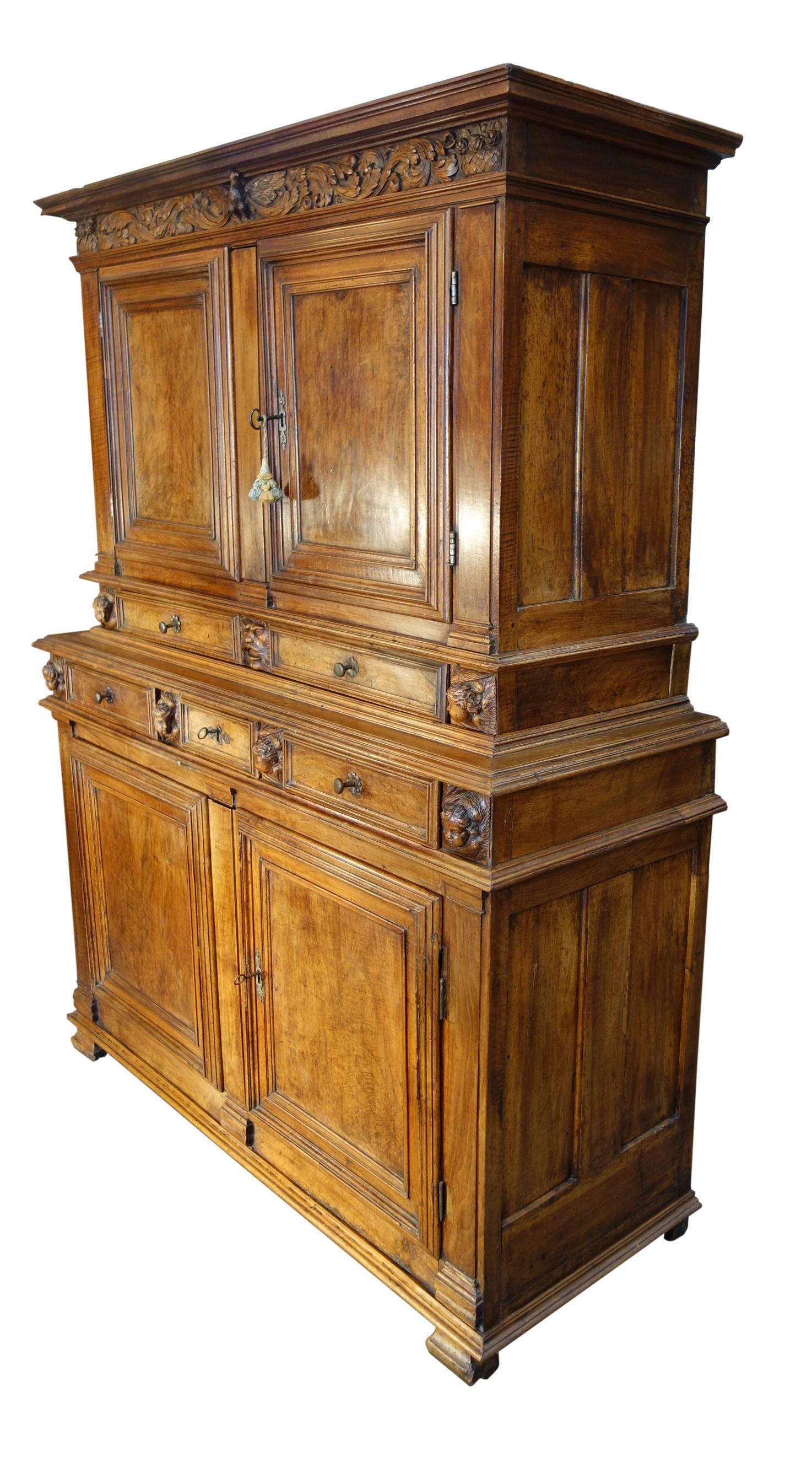 Impressive Tuscan Renaissance style double credenza hutch in solid walnut with old-world patina and hand-carved caryatids double door upper cabinet with lock and key, two-drawer and three-drawer stacked lower cabinet over double