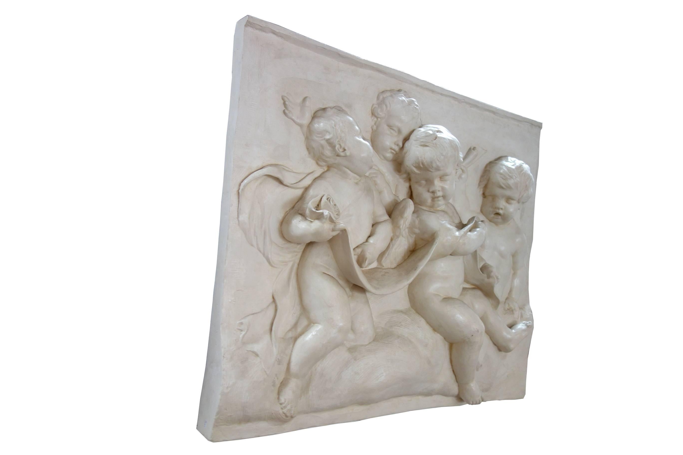 Charming high relief wall plaque in unusually large size, featuring four cherubs. Plaster patinated.

Dimensions are 38 1/2