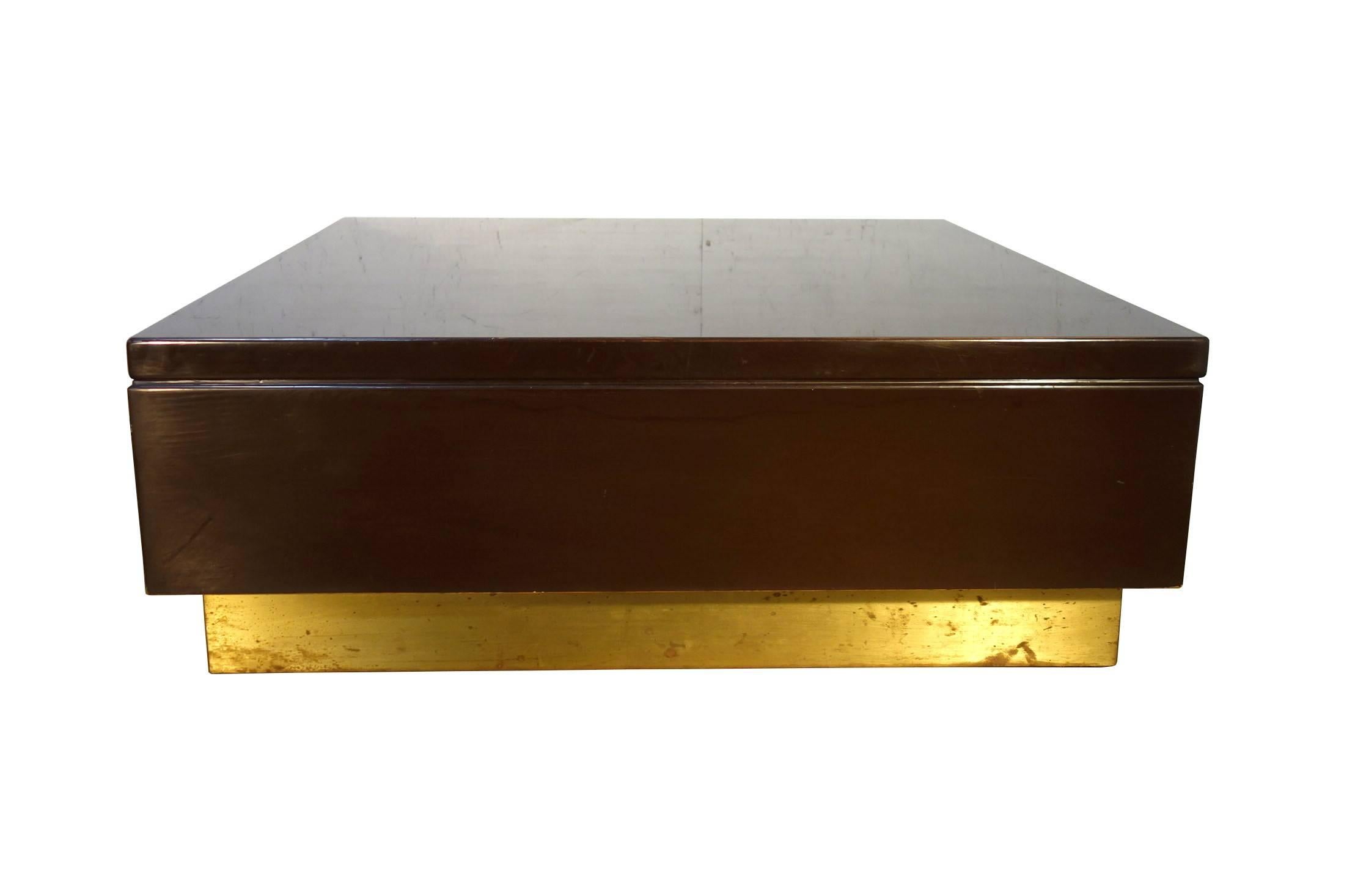 One of a beautiful set of two Italian design contemporary occasional tables 1970s. A square chocolate color lacquered plywood occasional table on a base of brass plates. Beautifully minimalistic with a metallic accent. This table with compliment a