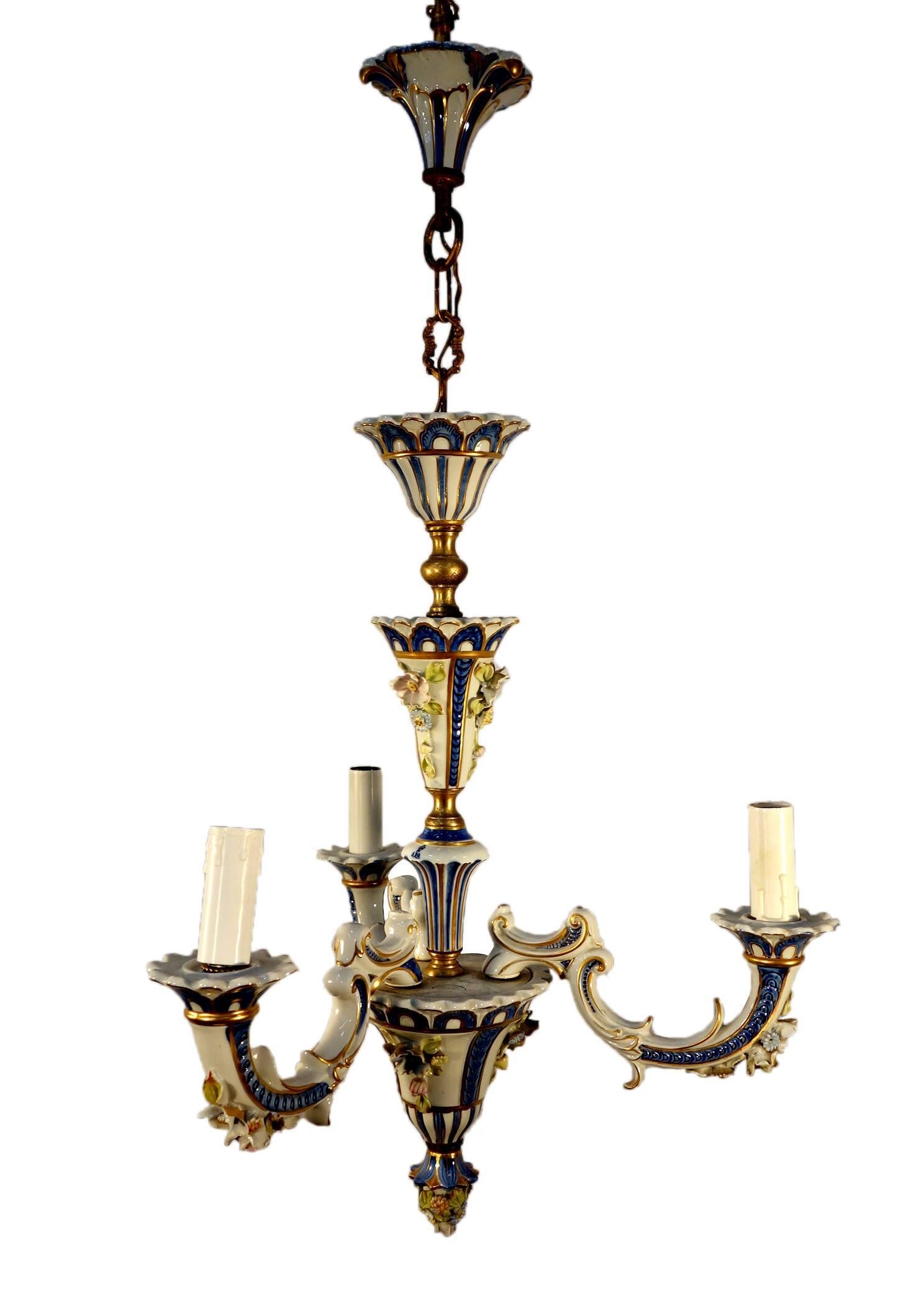 Darling little porcelain chandelier from Capodimonte. Beautiful and delicate elegance, white and blue with gold details and colorful little flowers.

Come with a matching little two light sconce. 

Measures: 32