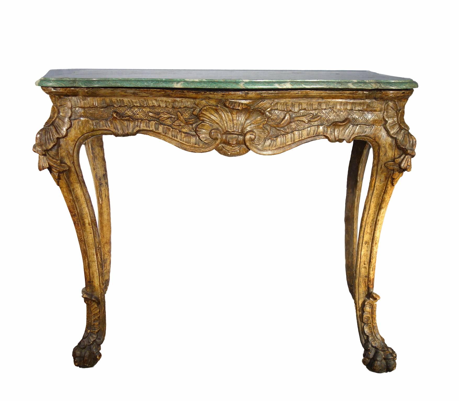 Deeply hand-carved baroque console table on four lion-feet legs gilded with the antique technique of 
