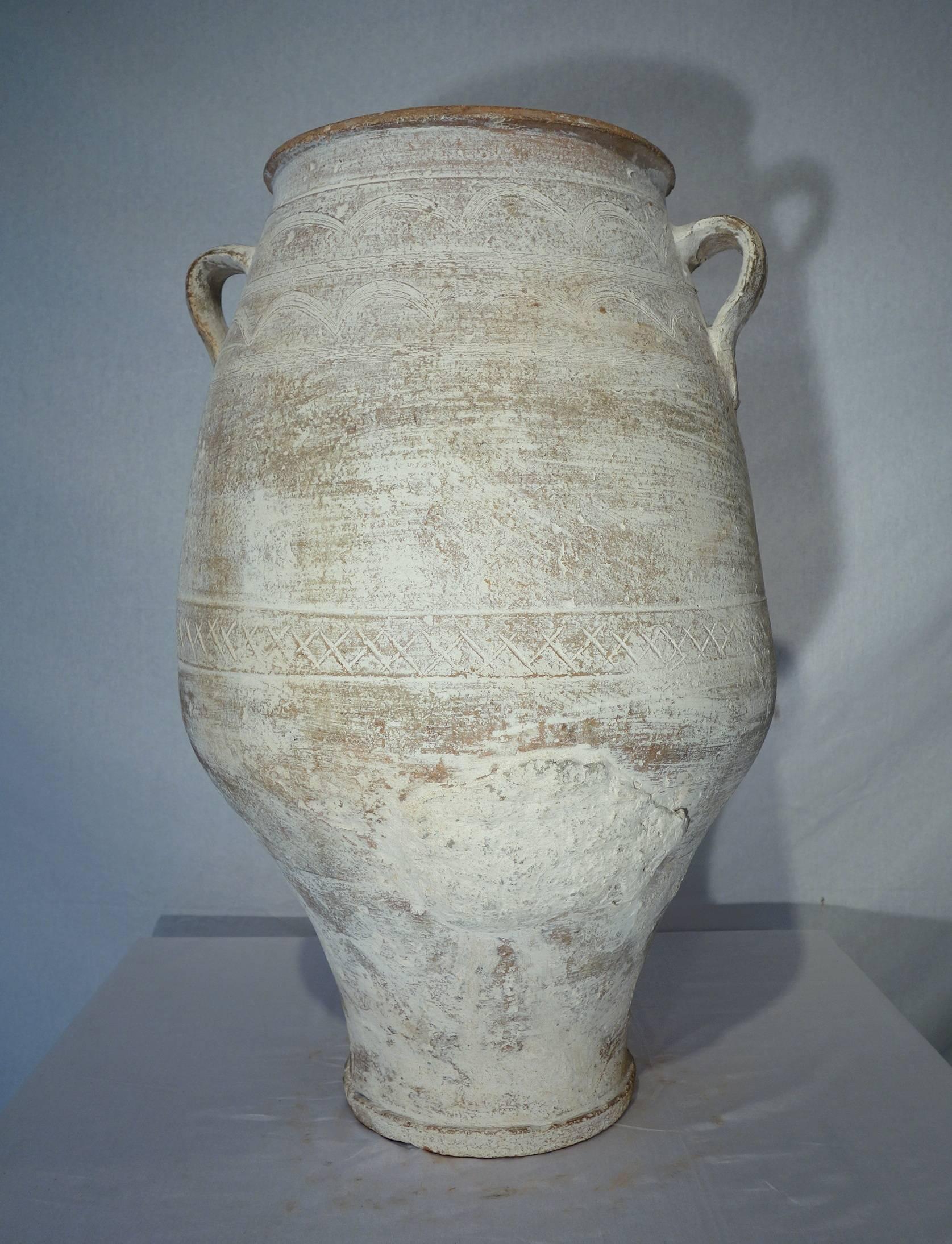 Simple line 19th century Greek water ampora wonderful white lime patina, it was once used as storage and shipping jars for water. Tapered shape toward the bottom with geometric and midline scoring. Heavy white patina.
