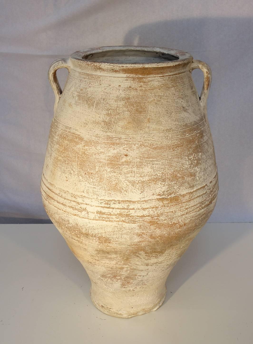 Simple line 19th century Greek water Ampora wonderful white lime patina, once used as storage and shipping jars for water. Tapered shape toward the bottom with geometric and midline scoring. Heavy white patina.
Pair of jars, similar in size and