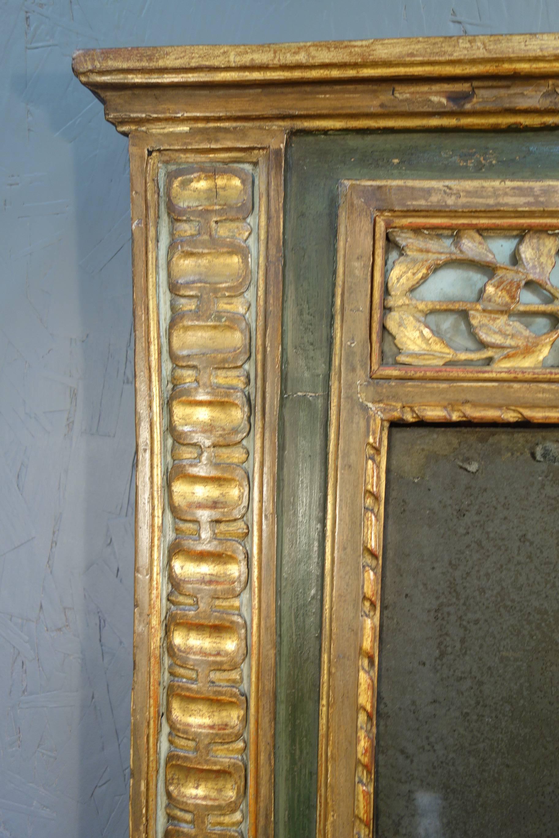 Early 19th century original silver mirror glass in gold gilded frame with green painted borders; hand-carved decorative wood insert in upper margin.

Measures: 41"H x 27.25"W x 2.5"D.