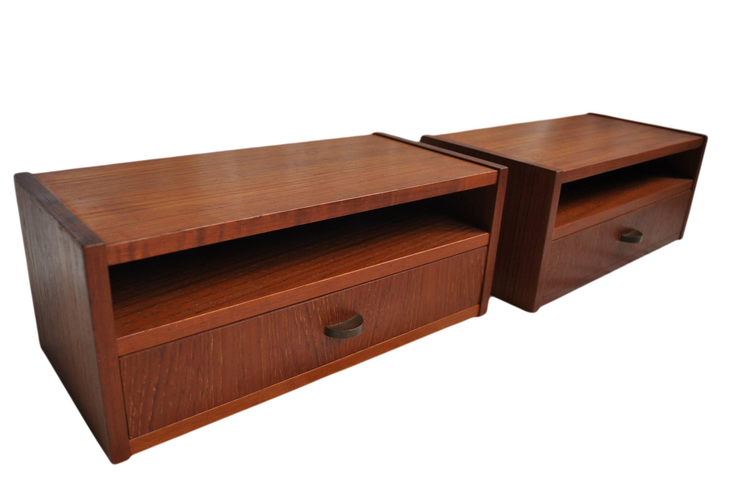 A pair of Mid-Century Danish Modern nightstands. Wall mounted. Constructed in teak with brass finger pulls, circa 1950.