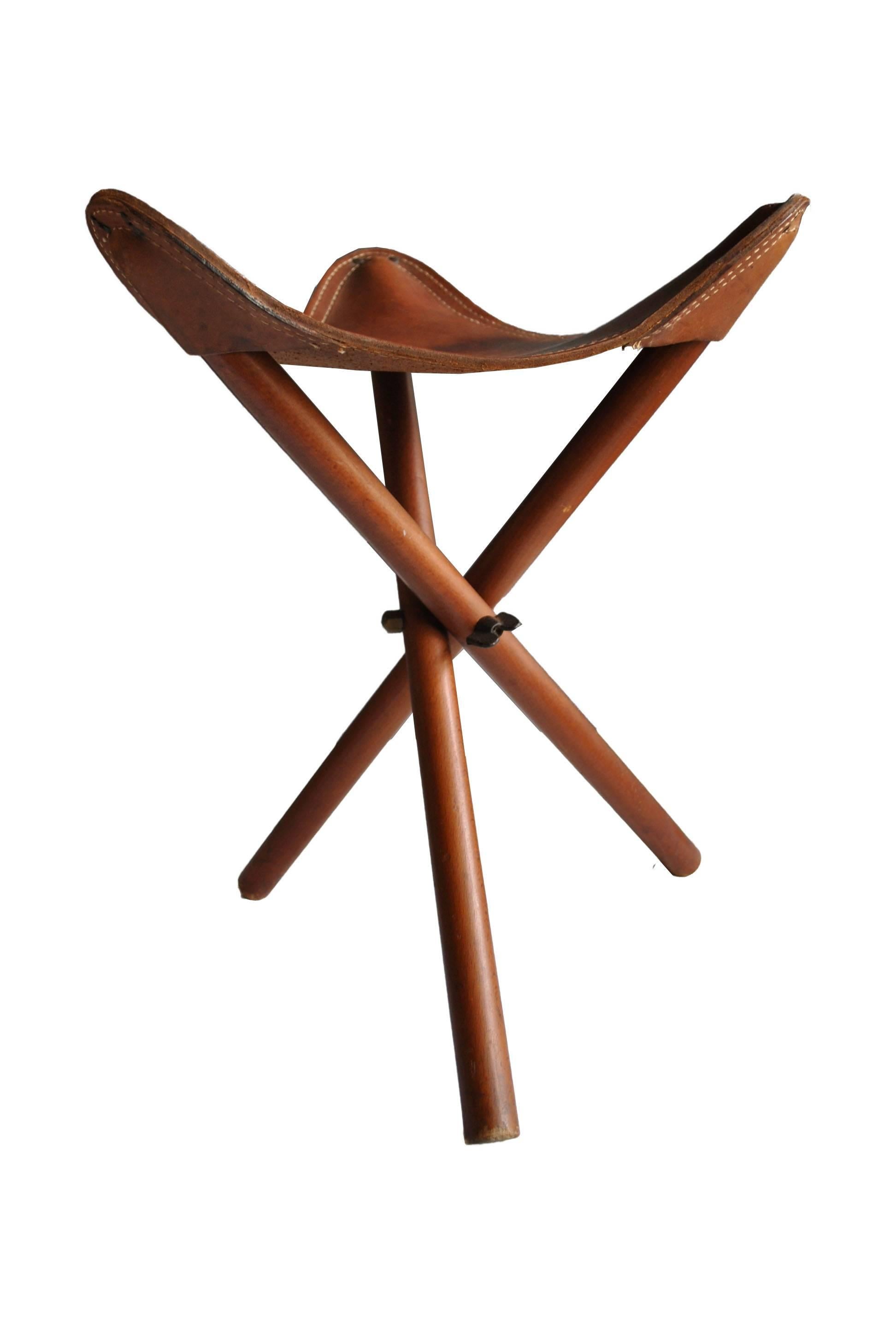 Folding tripod campaign stool. Thick saddle leather seat, early 20th century.