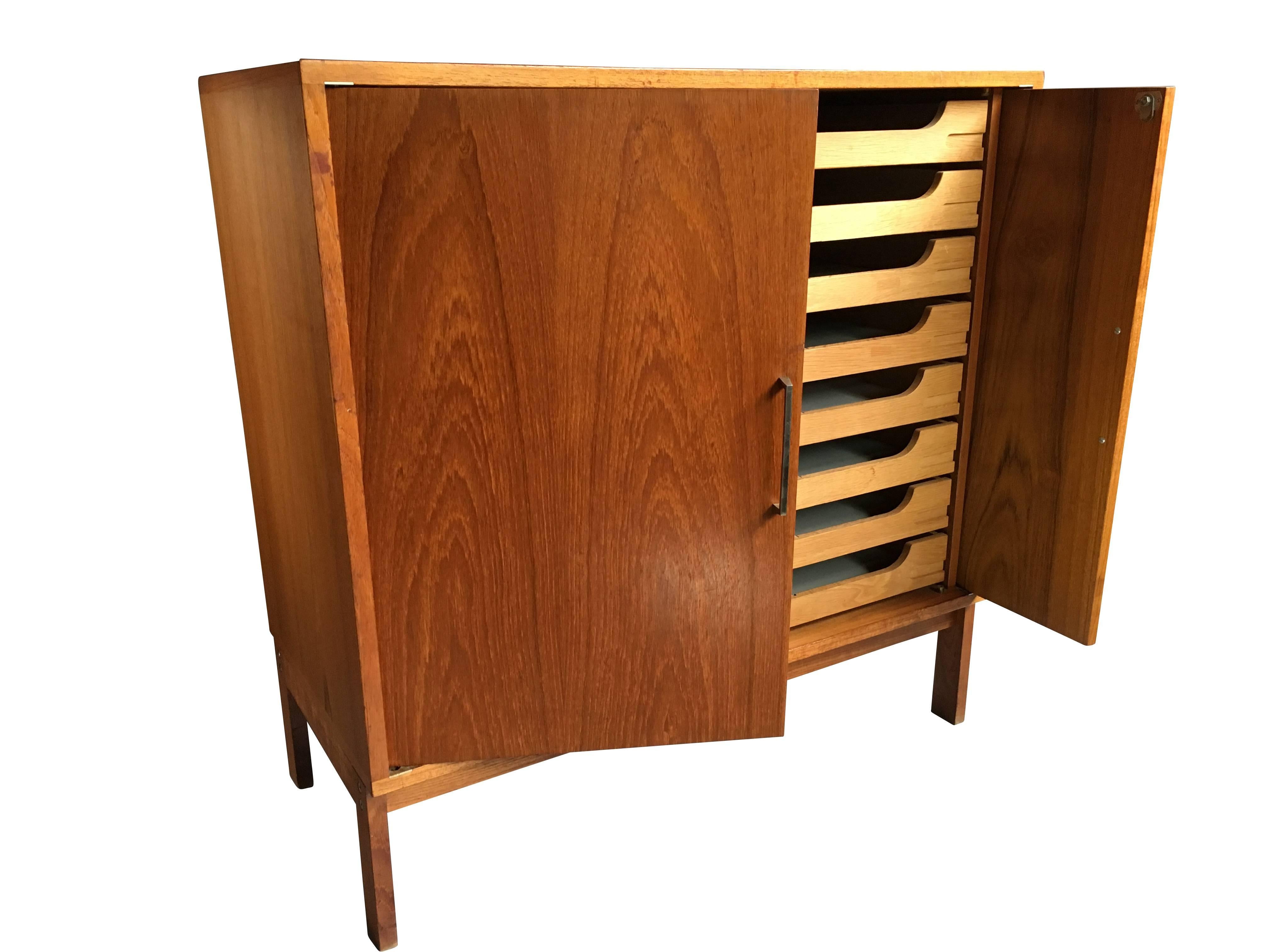 A Danish mid-century planchest/filing cabinet. Teak with oak drawers. Very clever slide fold-away doors.