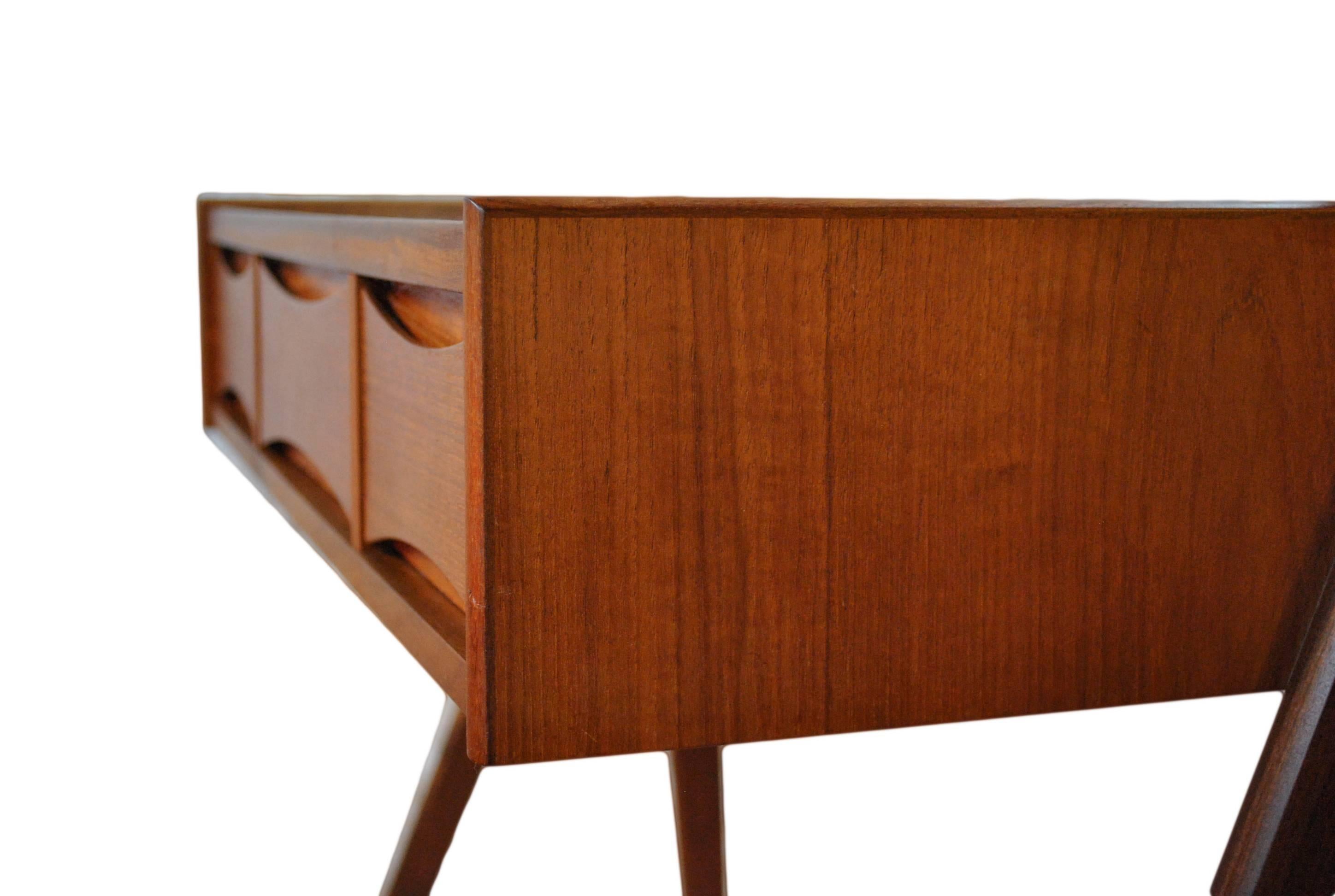 A rare piece designed by Arne Vodder, circa 1960, Denmark. Constructed in teak with a swivel mirror, black glass work surface and Vodders Classic bow tie drawer fronts.
This item is in fantastic vintage condition and dismantles easily for safe