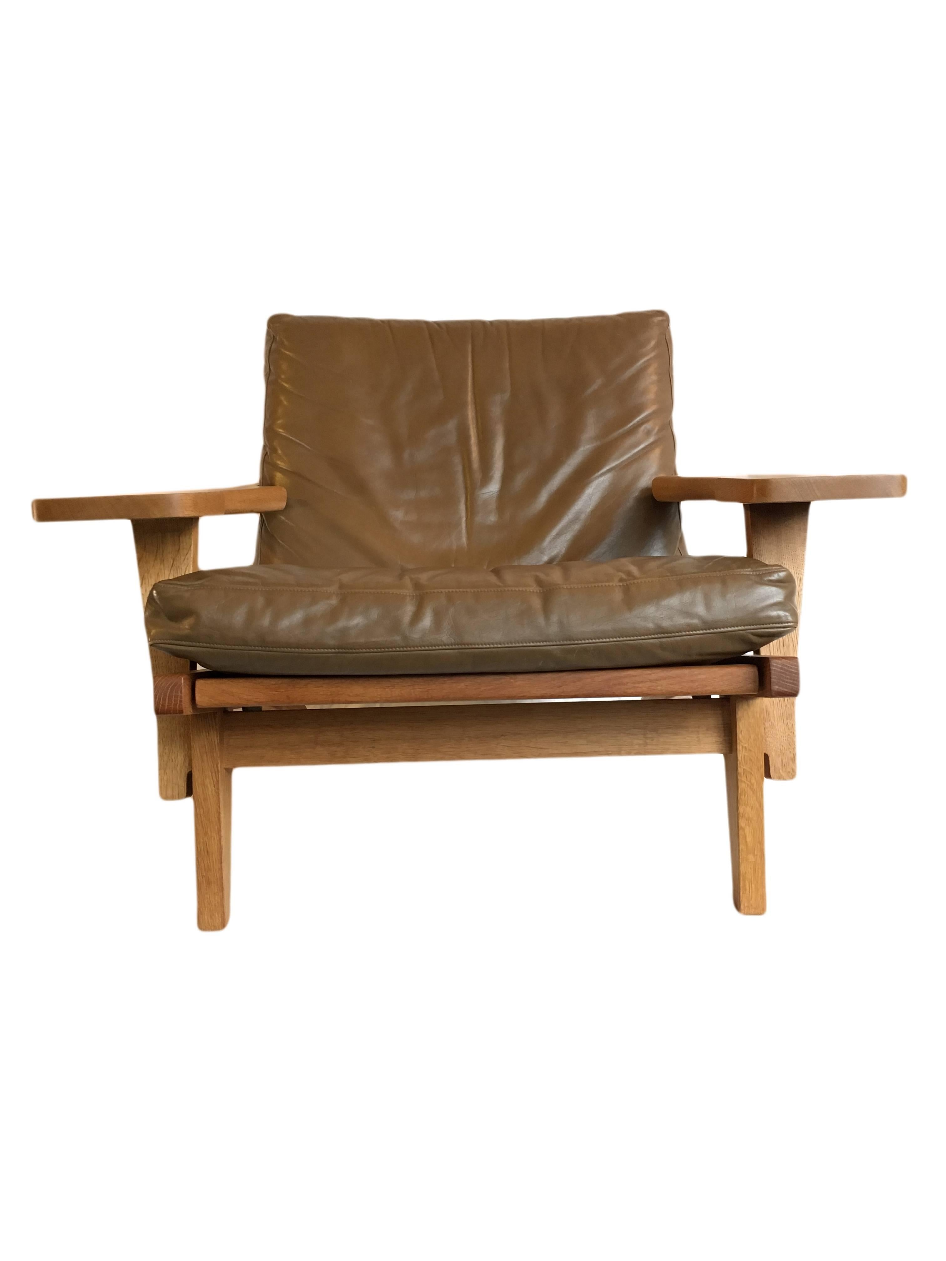 An original 1960s Hans J Wegner ge375 armchair. Produced by GETAMA, Denmark. Makers marks intact to underside. Constructed in oak with olive leather upholstery (other upholstery options available). This chair is in remarkable condition. Cleaned,