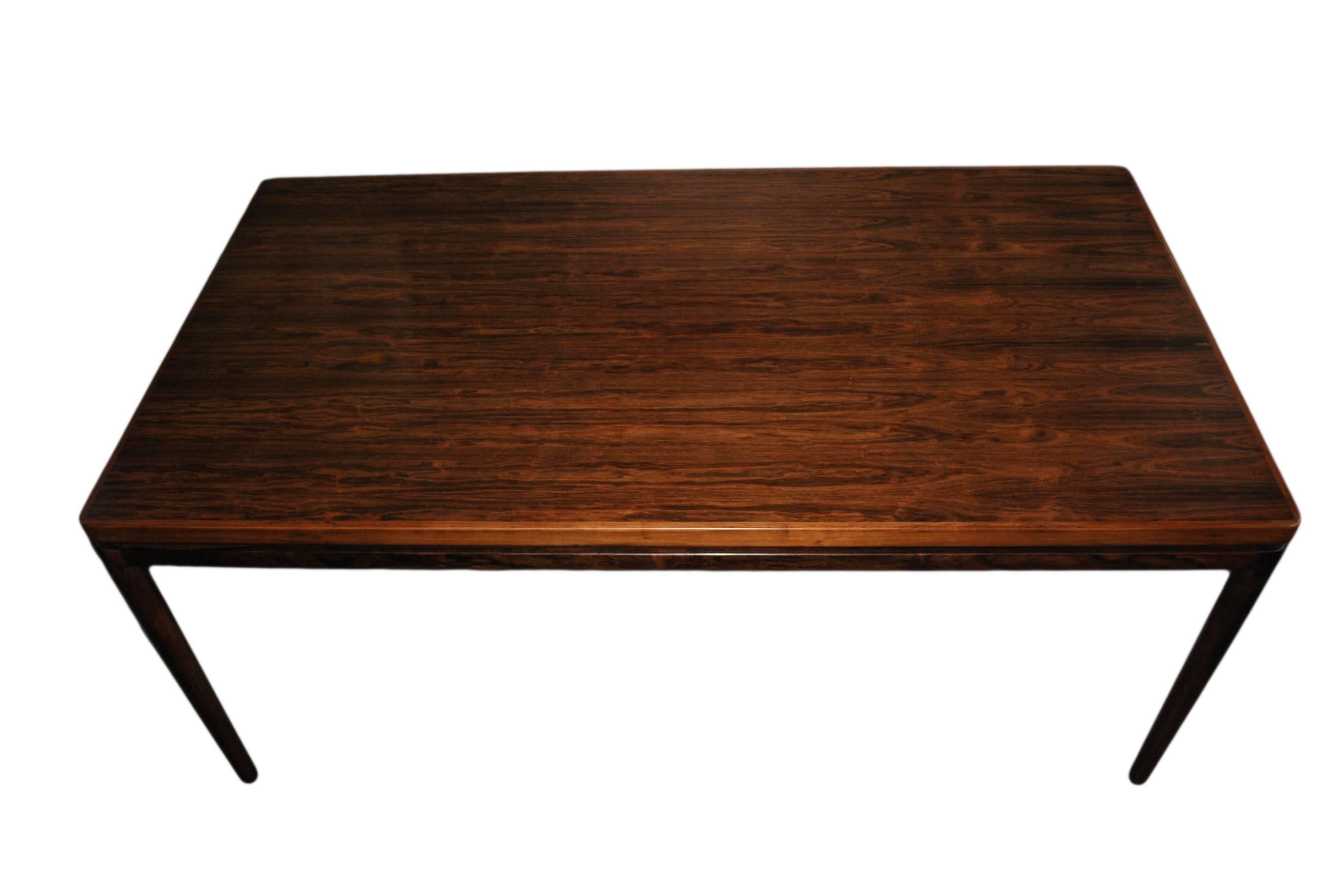 Brazilian rosewood dining table designed by Johannes Andersen for Christian Linneberg, Denmark, circa 1960. Finest quality. Large size table that comfortably seats 8 to 12 (ext). Table extends via hidden slides and leaves. Each extending leaf is
