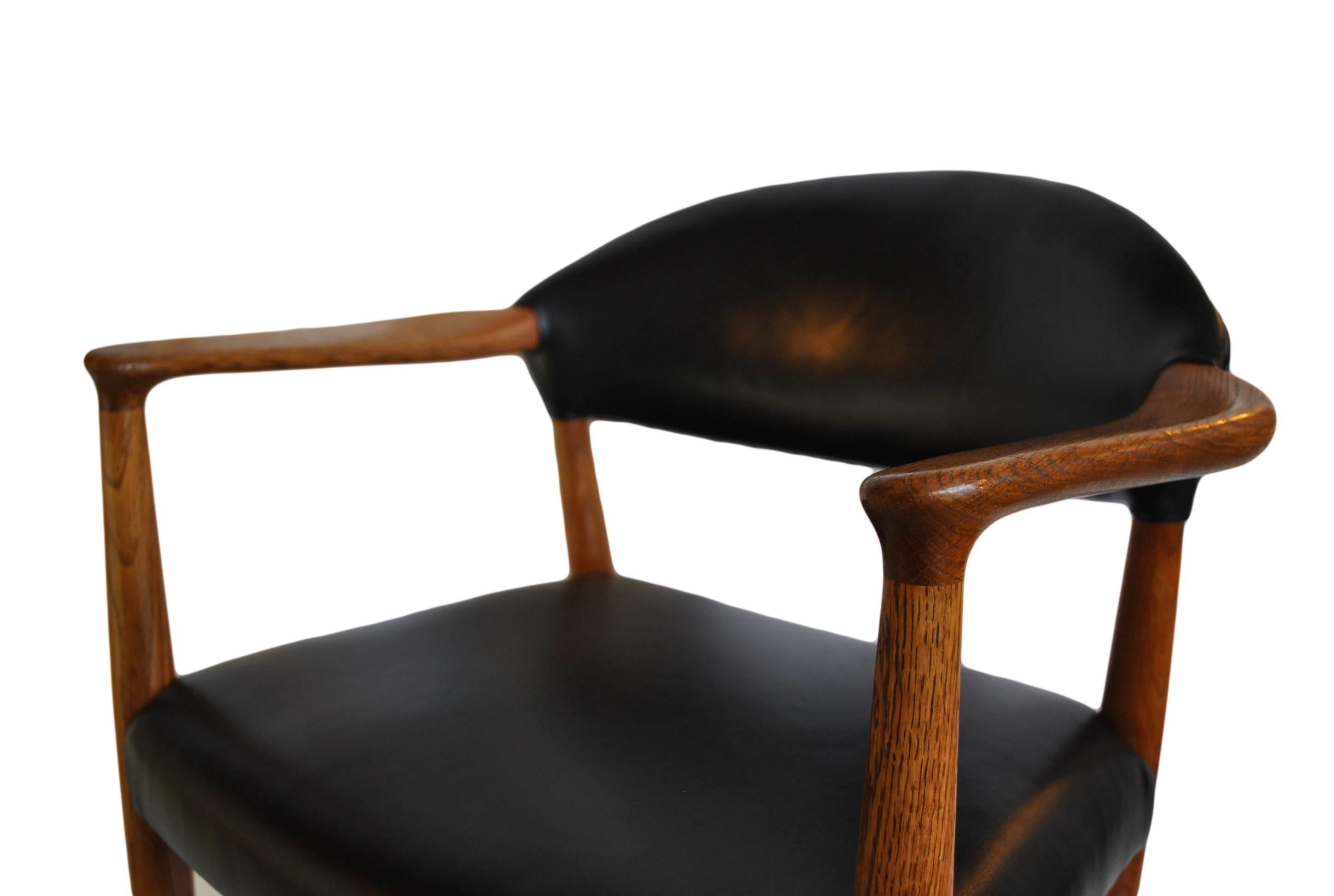 Polished European oak frame - completely re-upholstered in crest black  anthracite Italian leather. Fabulous chair design from Kurt Olsen, Denmark, circa 1955.