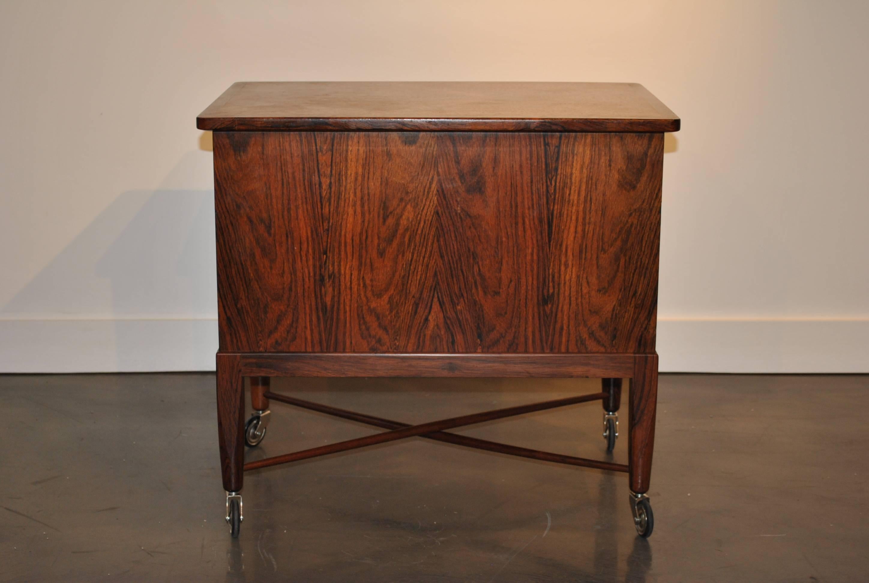 Lovely handcrafted Swedish chest on wheels. Vivid Santos with wonderful grain features. The interior holds two sliding tray inserts with many compartments and storage beneath. Great condition throughout.
Insured shipping.
 