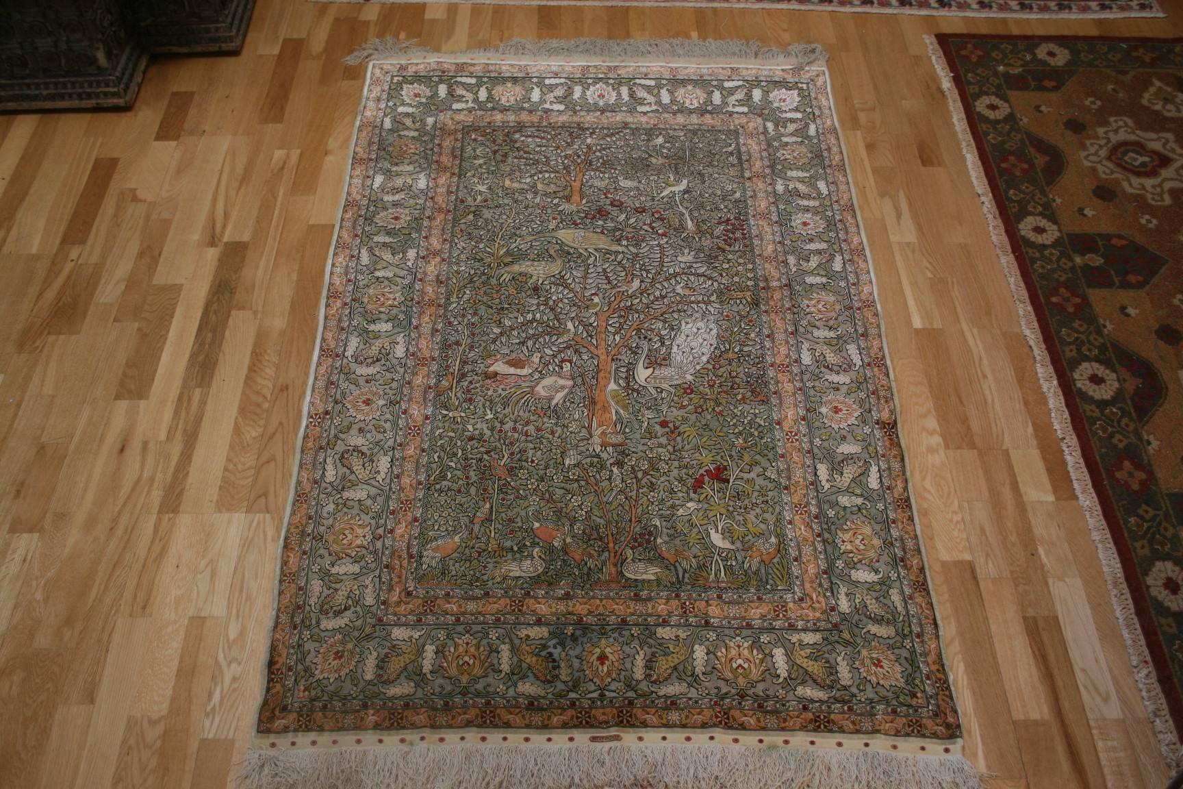 A vintage silk and metallic Turkish Hereke woven and signed by "Ozipek" workshops in Hereke. This design is a famous Mughal Indian 'Tree of Life with Birds'.  The original 16th-17th century piece is in a museum. The knot count per square
