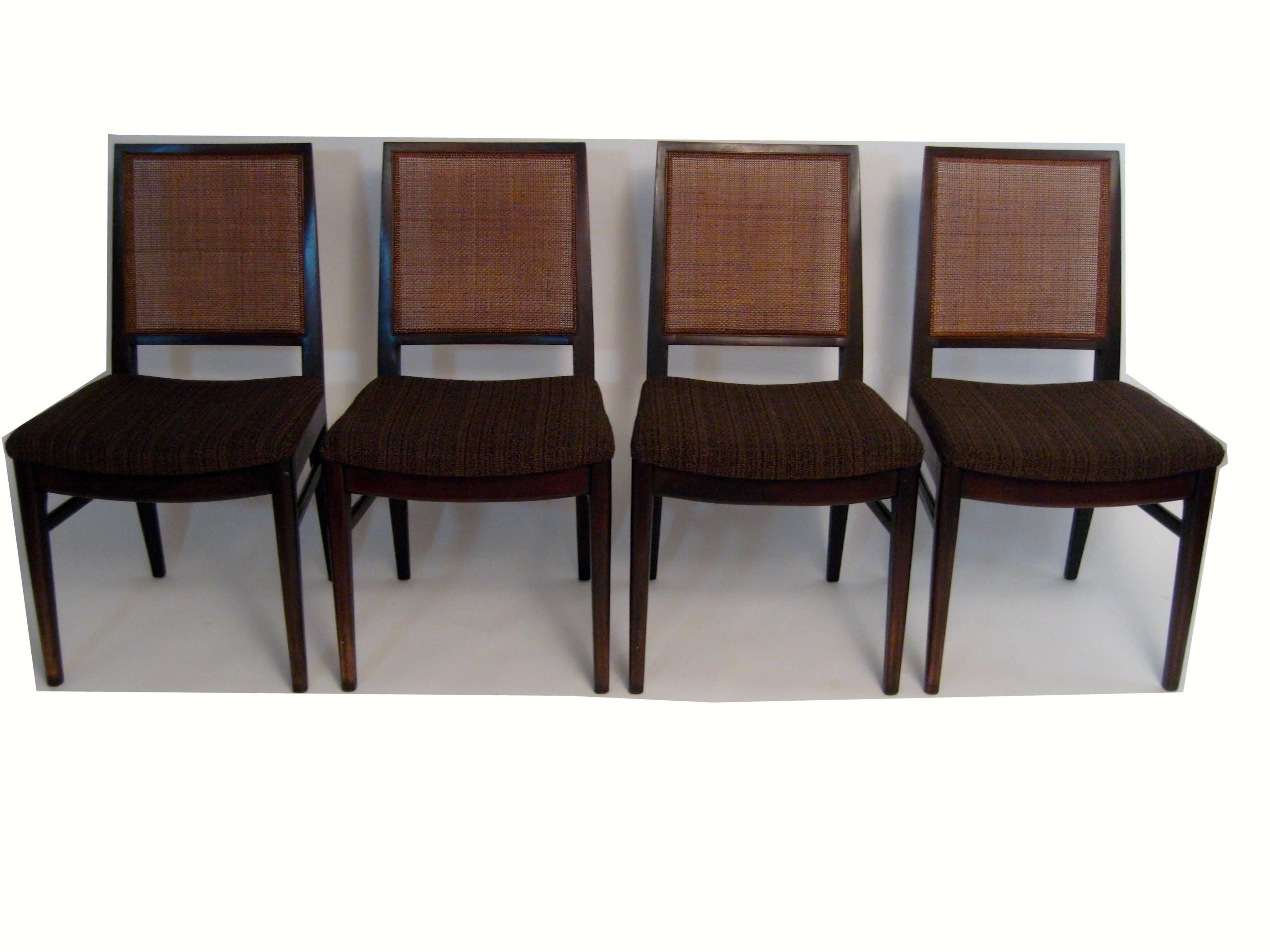 Exquisite set of six chairs retailed at John Stuart in New York City. The set consists of four side chairs with caned backs and upholstered seats and two armchairs with upholstered seats and backs. Solid walnut construction. Original, good dark