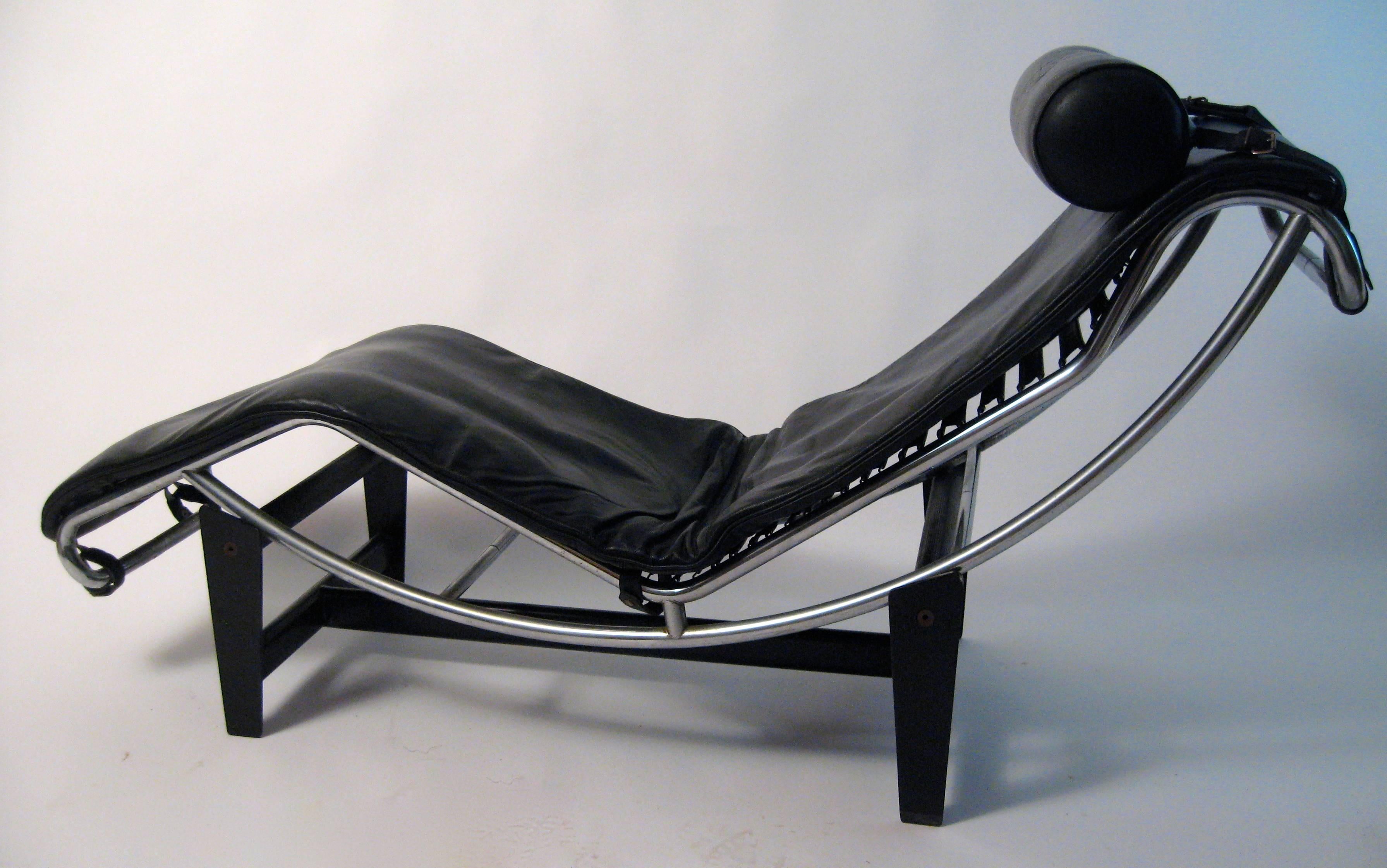 Collaborative design by the modern masters: Le Corbusier, Charlotte Perriand and Pierre Jeanneret. The chaise features supple black leather cushion and headrest, rubberized sling strapping, chrome finished frame, matte black steel base. Signed and