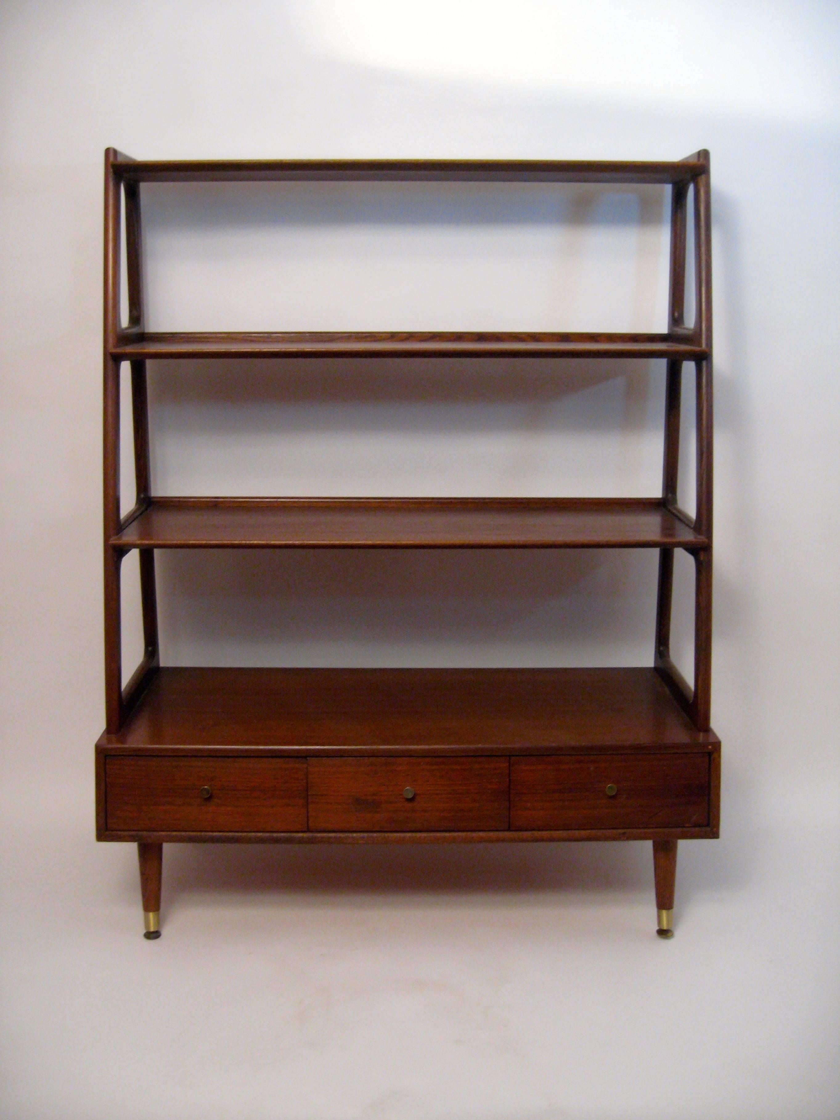 Tiered and graduated walnut shelves supported by solid oak upright supports and finished with three drawers. Solid, free standing bookcase or etagere that has a finished back and can be used in an 'open floor plan' as a partition or room divider.
