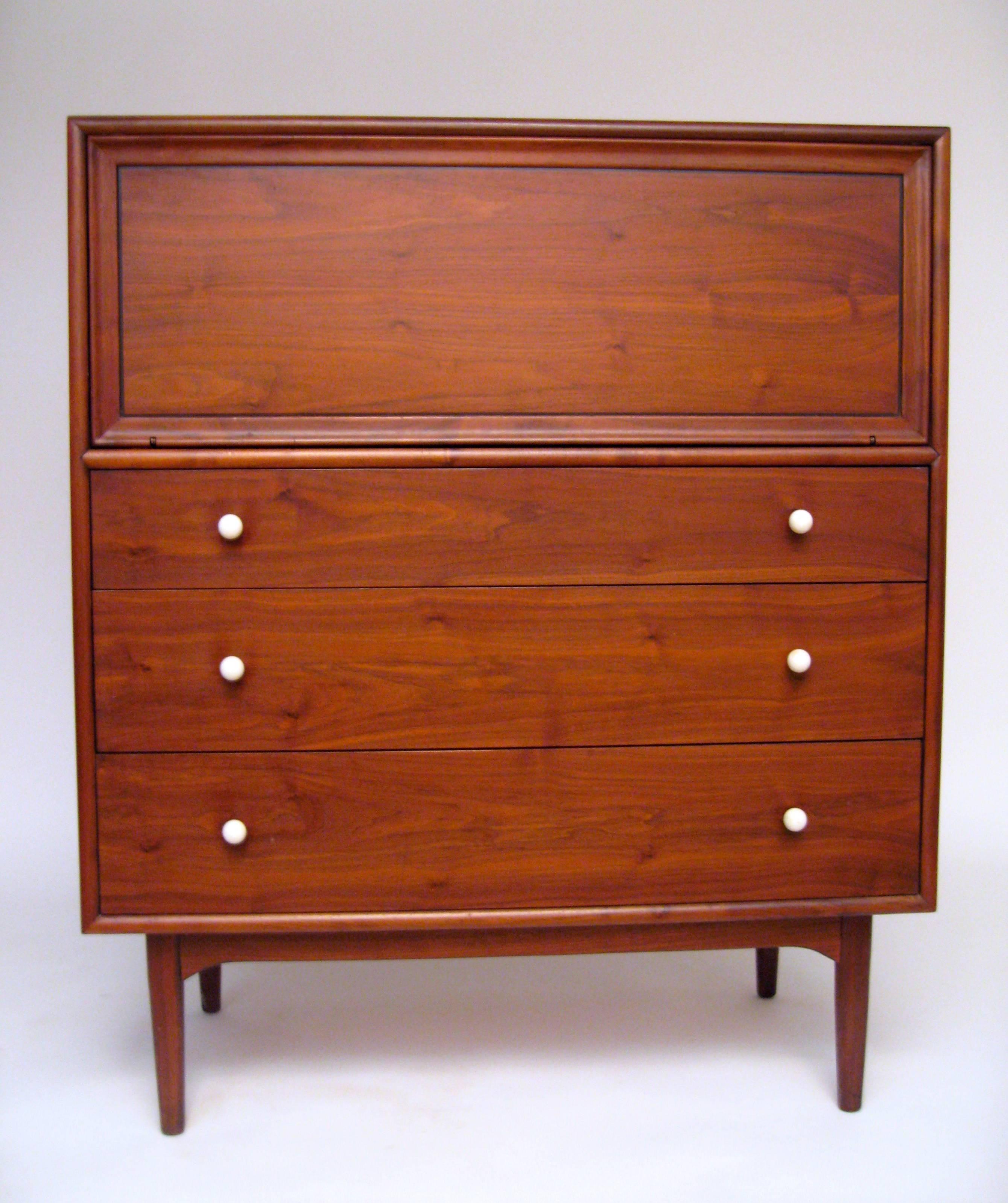 Declaration for Drexel series designed by Kipp Stewart and Stewart MacDougall. Made of wonderfully figured solid and walnut veneers. Tapered legs. Two hidden divided drawers over three drawers. Small plastic caddy for tie clips or cuff links. Round