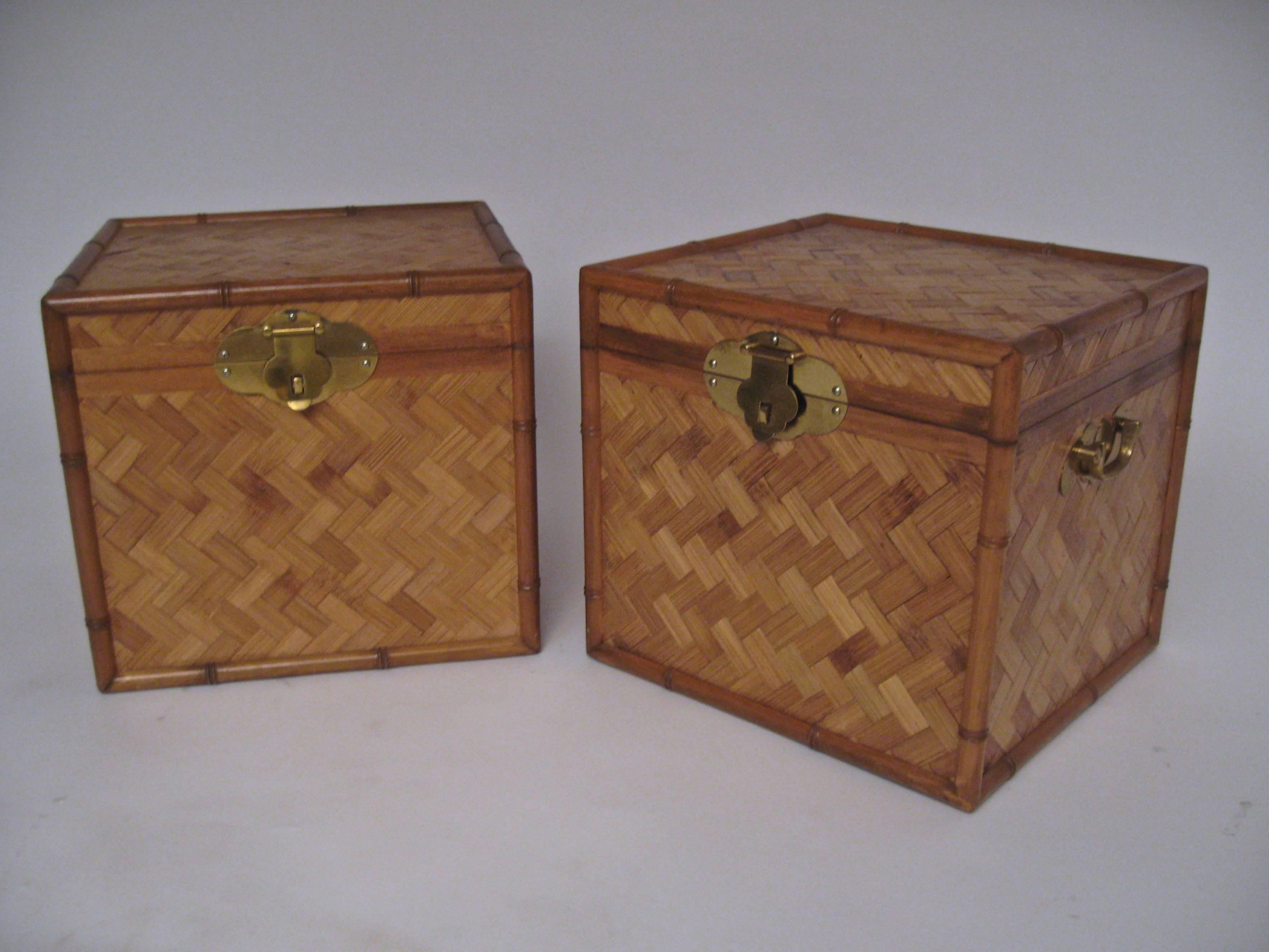 Wonderful pair of split bamboo and brass storage cube end tables. Solid brass hardware and hasp lock. Locks not included. Woven bamboo exterior with half round solid bamboo edge accents. Deep compartment storage. 