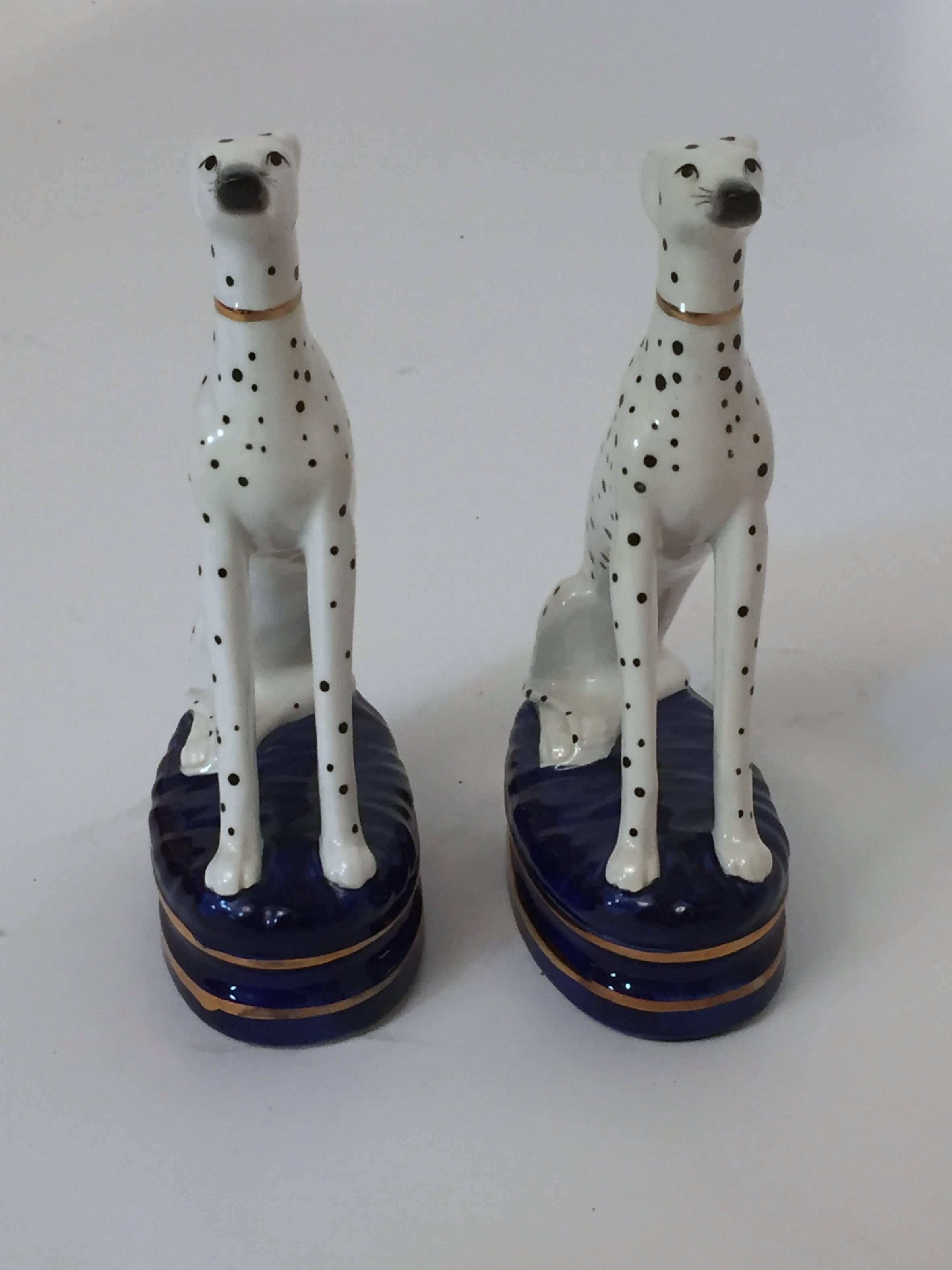 Pair of seated and attentive porcelain Dalmatian figurines for Fitz and Floyd. Hand painted porcelain with cobalt blue bases and gilded accents. Signed FF, Japan with paper label.