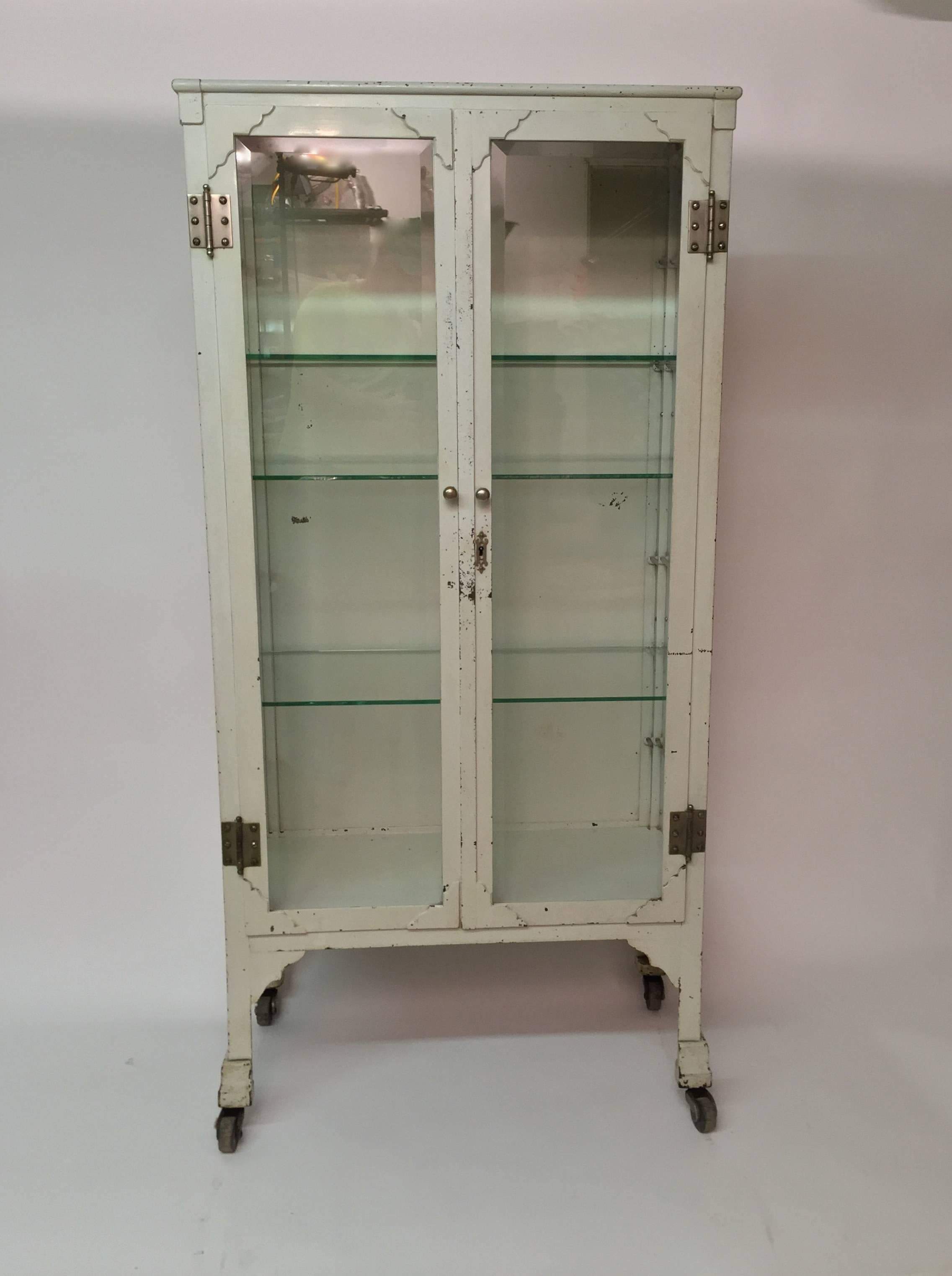Amazing display showcase or display cabinet. The steel case cabinet retains the four original bevel glass panels, six original glass shelves (green edge) and the key. Four hard rubber casters and nickel hardware,

circa 1920-1930.