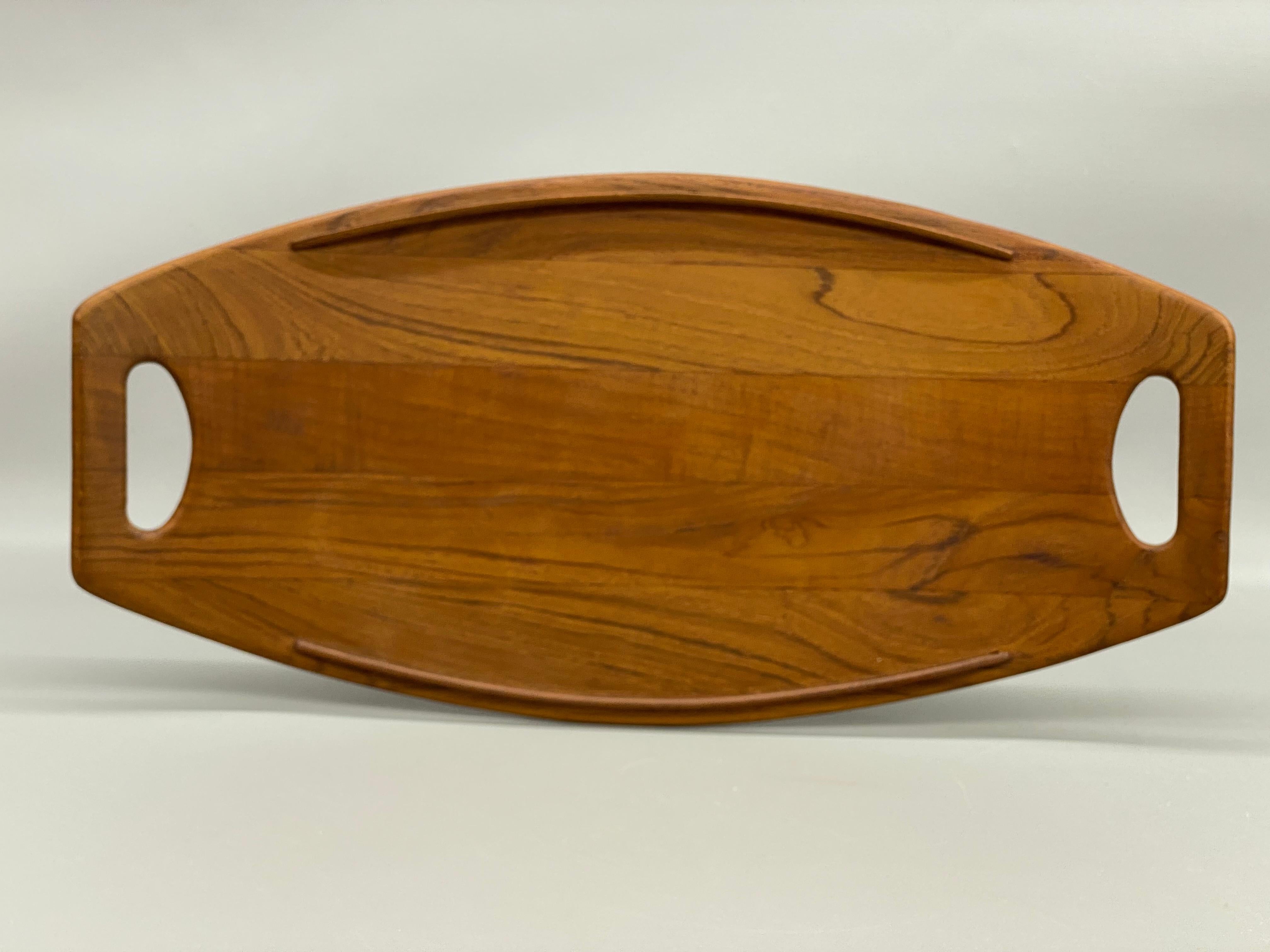 A nice early example Staved Teak Dansk platter. Solid and finely grained teak construction. Burn in mark on the bottom, 801, Staved Teak, Dansk, Denmark, IHQ. Quality and exceptional sculptural design by Jens Quistgaard for Dansk.

Jens Harald