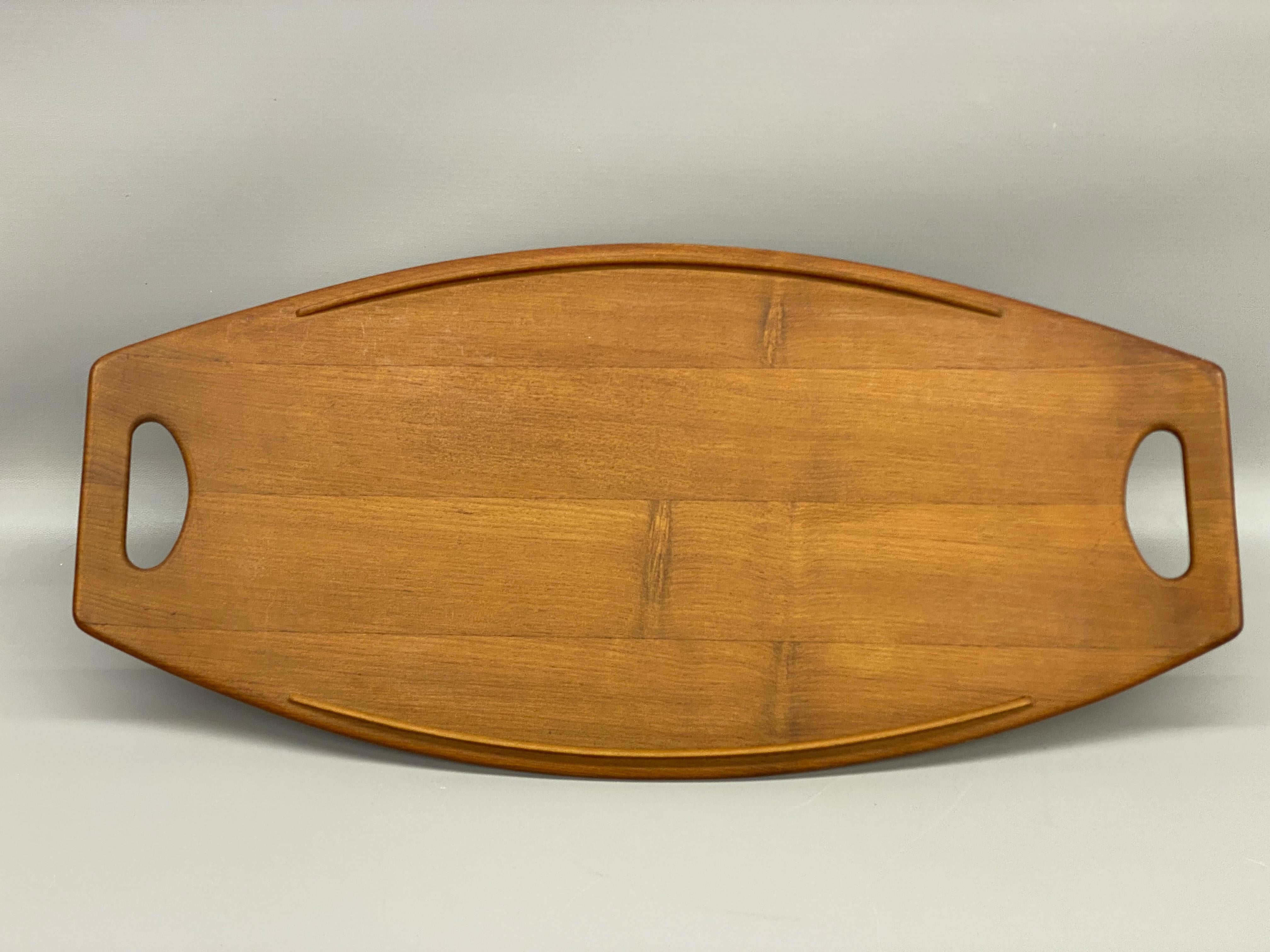 A nice early example Staved Teak Dansk platter. Solid and finely grained teak construction. Faint burn in mark on the bottom, 802, Staved Teak, Dansk, Denmark, IHQ. Quality and exceptional sculptural design by Jens Quistgaard for Dansk.

Jens Harald