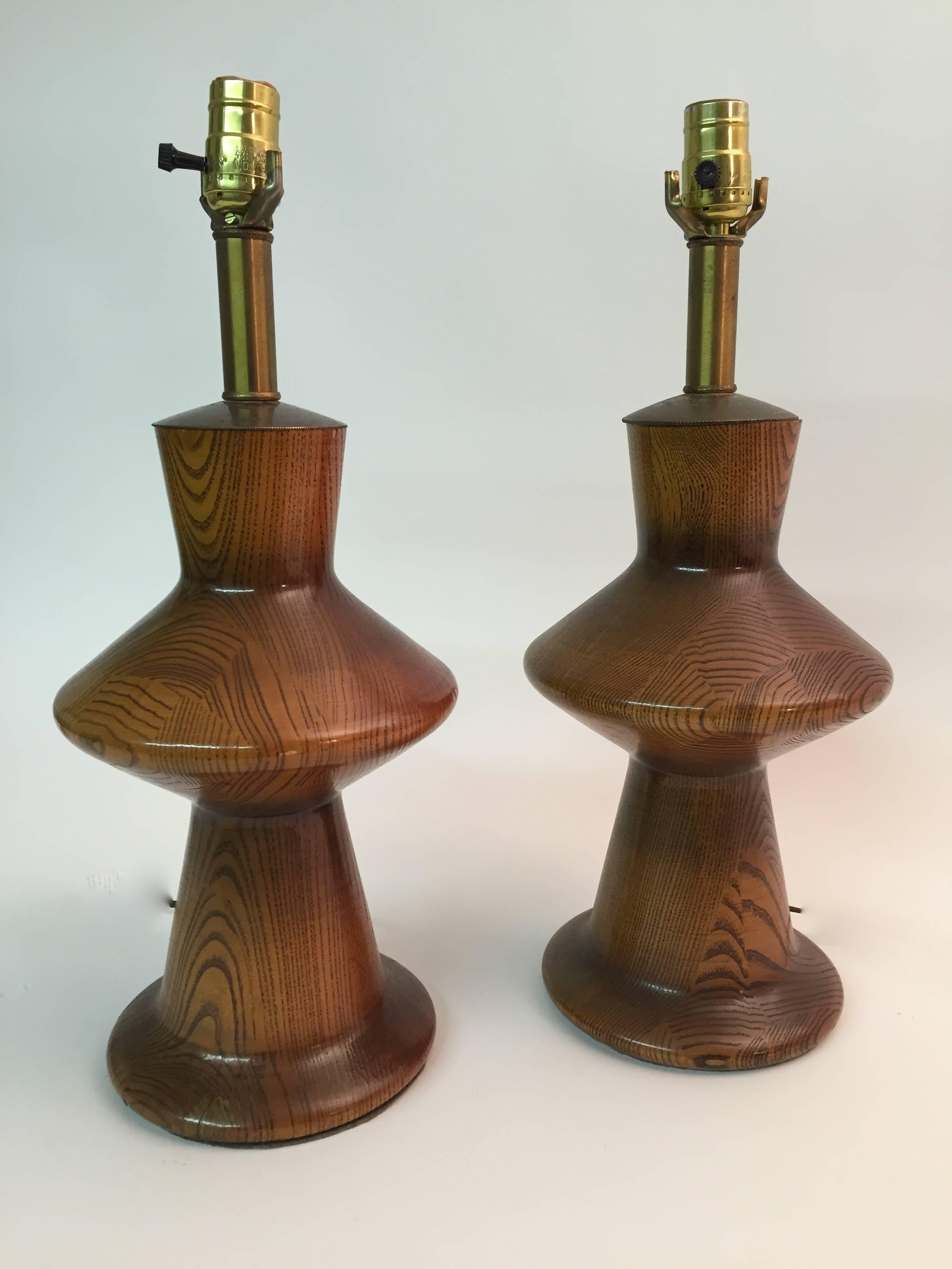 Gorgeous pair of turned oak modern lamps, circa 1950-1960. Original wiring in working condition. Harps not included.