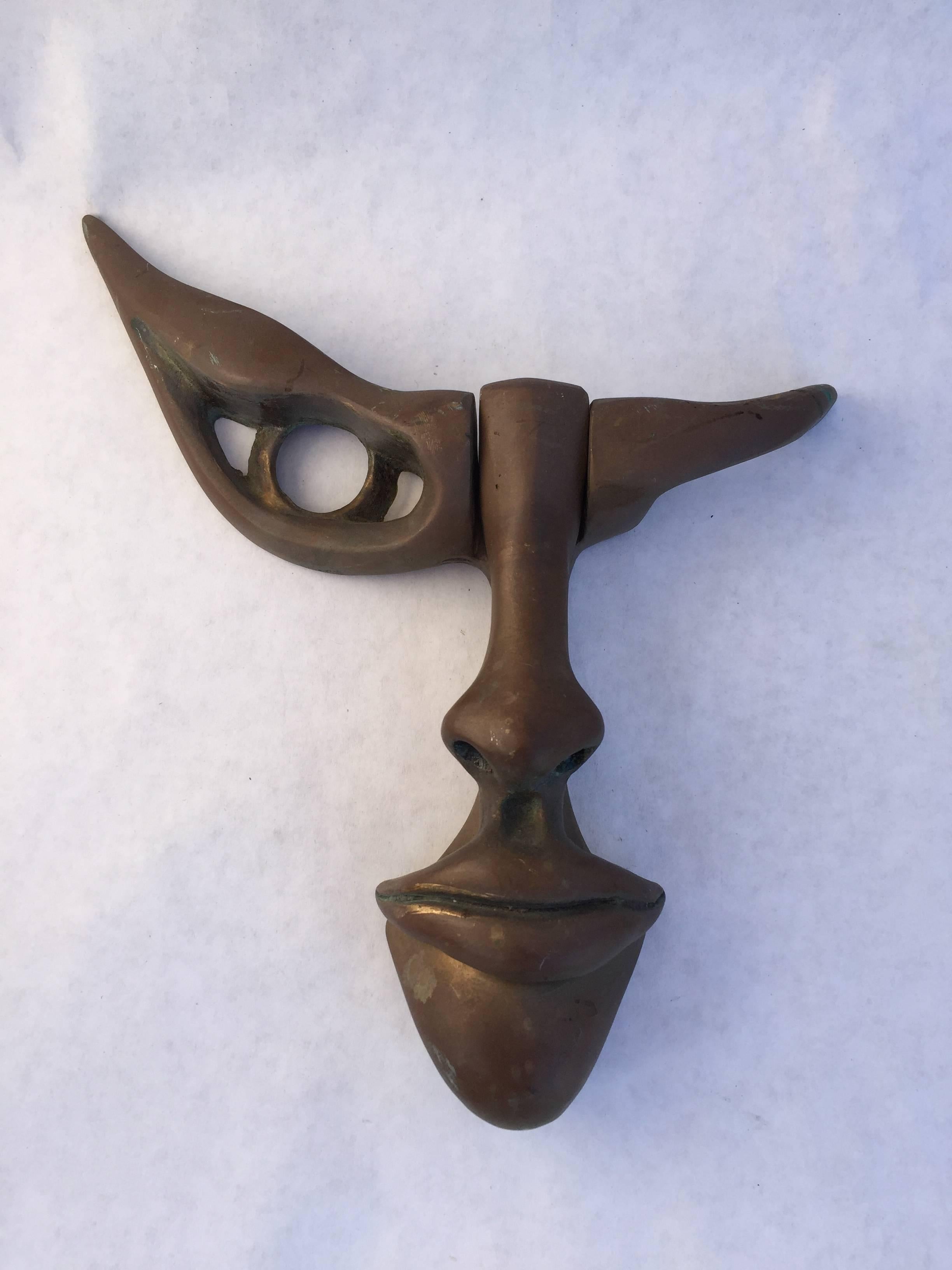 The cast bronze door knocker sets itself apart from every other piece of door hardware. Rich original mellow patina. Signed Cellura underneath the nose. Die stamped, 1996 (possibly the date of origin) and 326. The nose and lips strike the upper chin