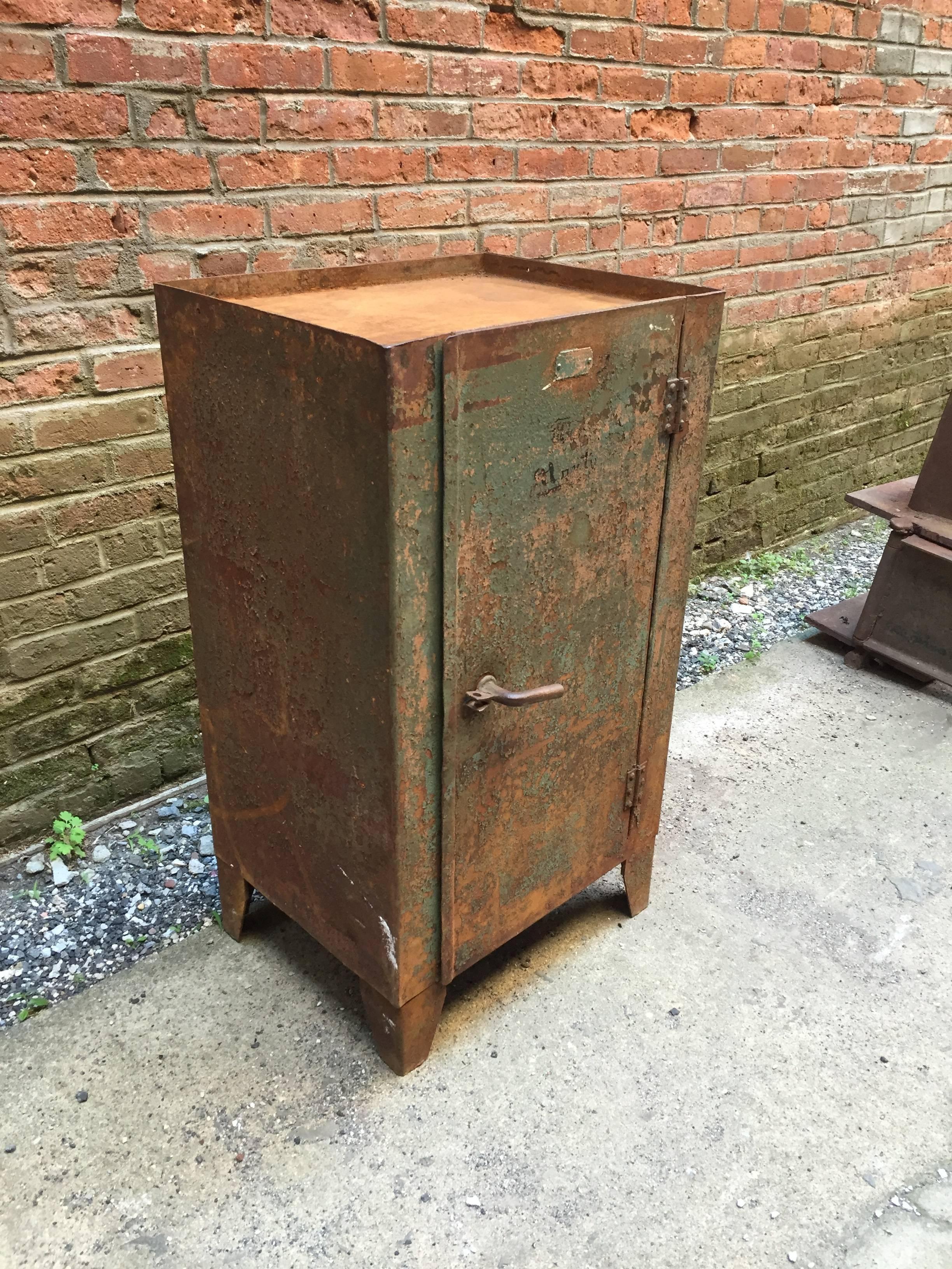 Locking Industrial cabinet that is aged to perfection. Overall rust and Industrial green chipped paint. Yellow painted interior. Spectacular twist handle, circa 1930-1940.